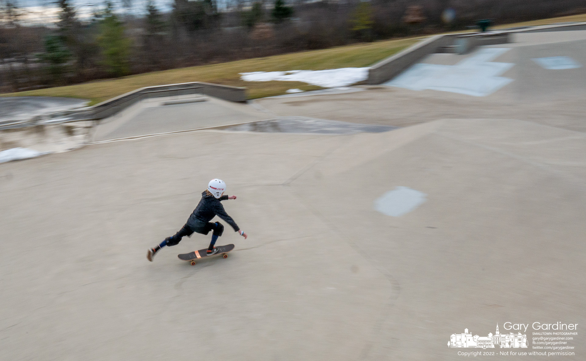 A young skater pushes off as he approaches a slope at the center of the Westerville skatepark that was just cleared of most of the snow by a group of skaters hoping for a few days of relatively clear winter weather to ply their sport. My Final Photo for December 30, 2022.