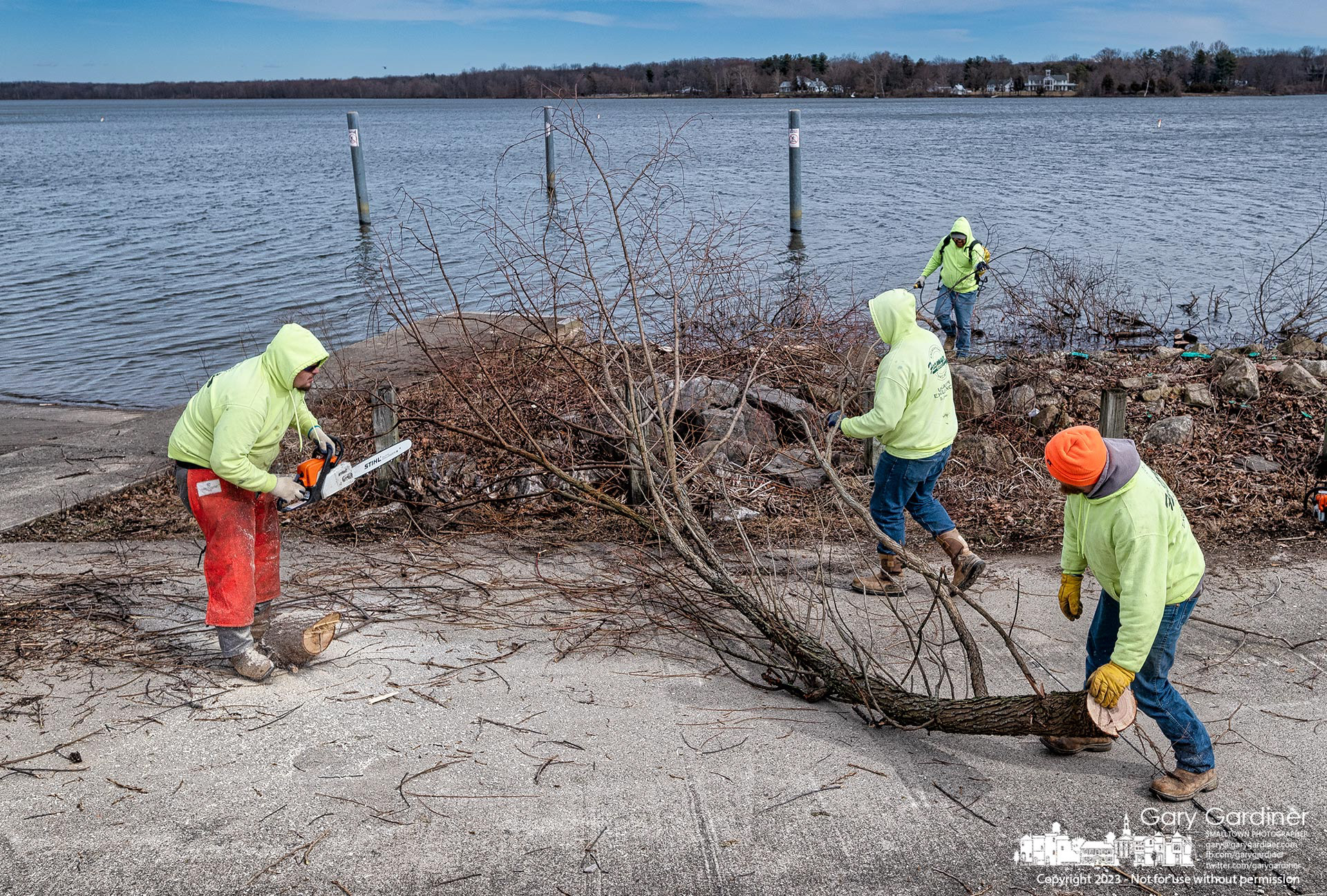 A work crew clears trees and bushes from riprap near the Red Bank boat launch on Hoover Reservoir to clear the rocks of vegetation than can damage its purpose of protecting the shoreline. My Final Photo for February 21, 2023. 