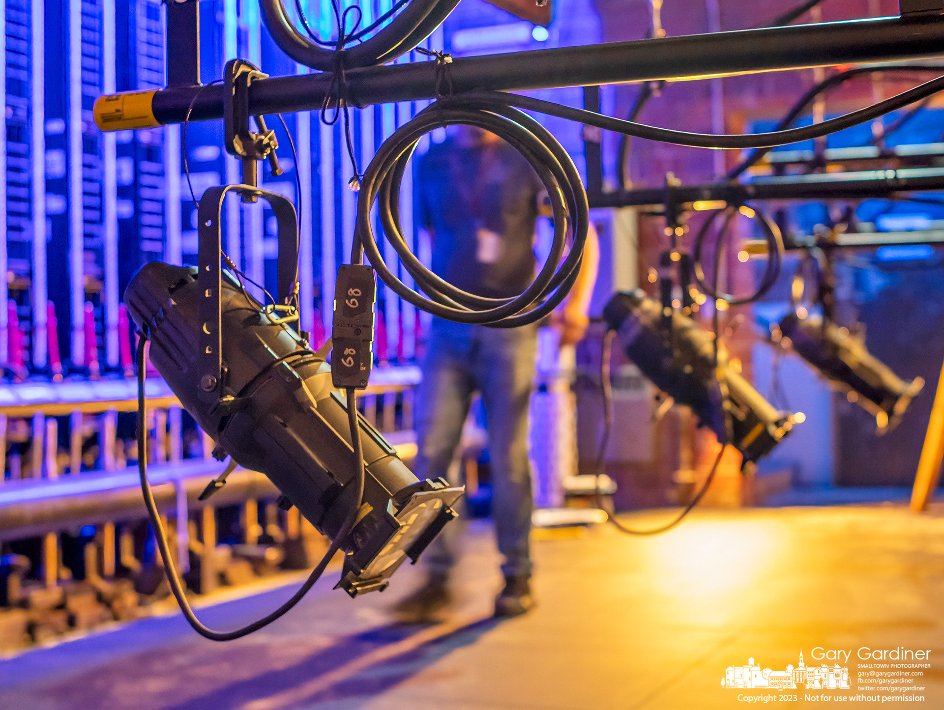 A stagehand walks past lights lowered for adjustment and testing on the newly repaired stage floor at Cowan Hall on the Otterbein University campus where the theater department continues to repair damage to the stage. My Final Photo for April 5, 2023.