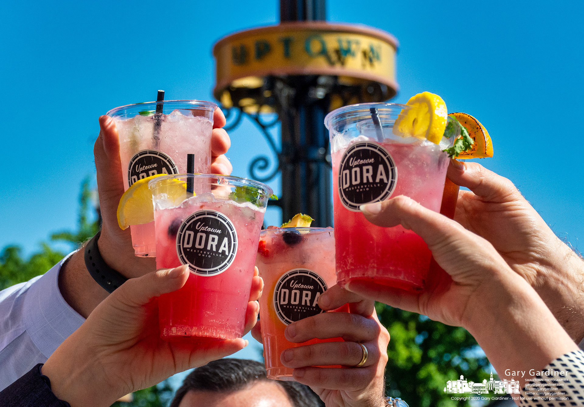 Celebrants hold aloft their Designated Outdoor Refreshment Area labeled alcohol beverage cups 20 minutes after the DORA ordinance went into effect allowing alcohol beverages in parts of Uptown Westerville, home of the Anti-Saloon League and prohibition. My Final Photo for June 17, 2021.