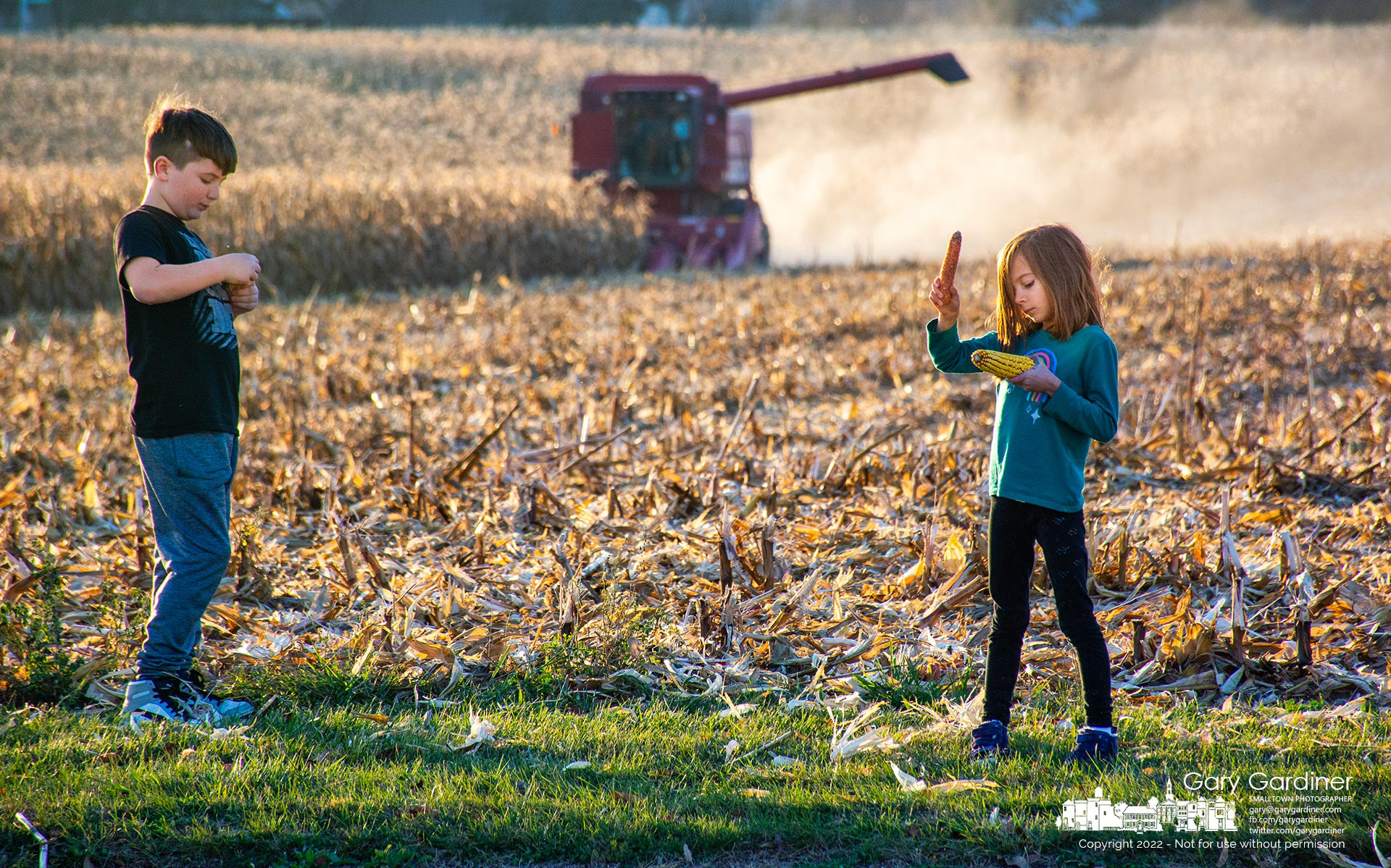 A brother and sister play with ears of corn as they wait their turn after their brother finishes his ride in the combine harvesting corn at the Braun Farm. My Final Photo for November 23, 2022