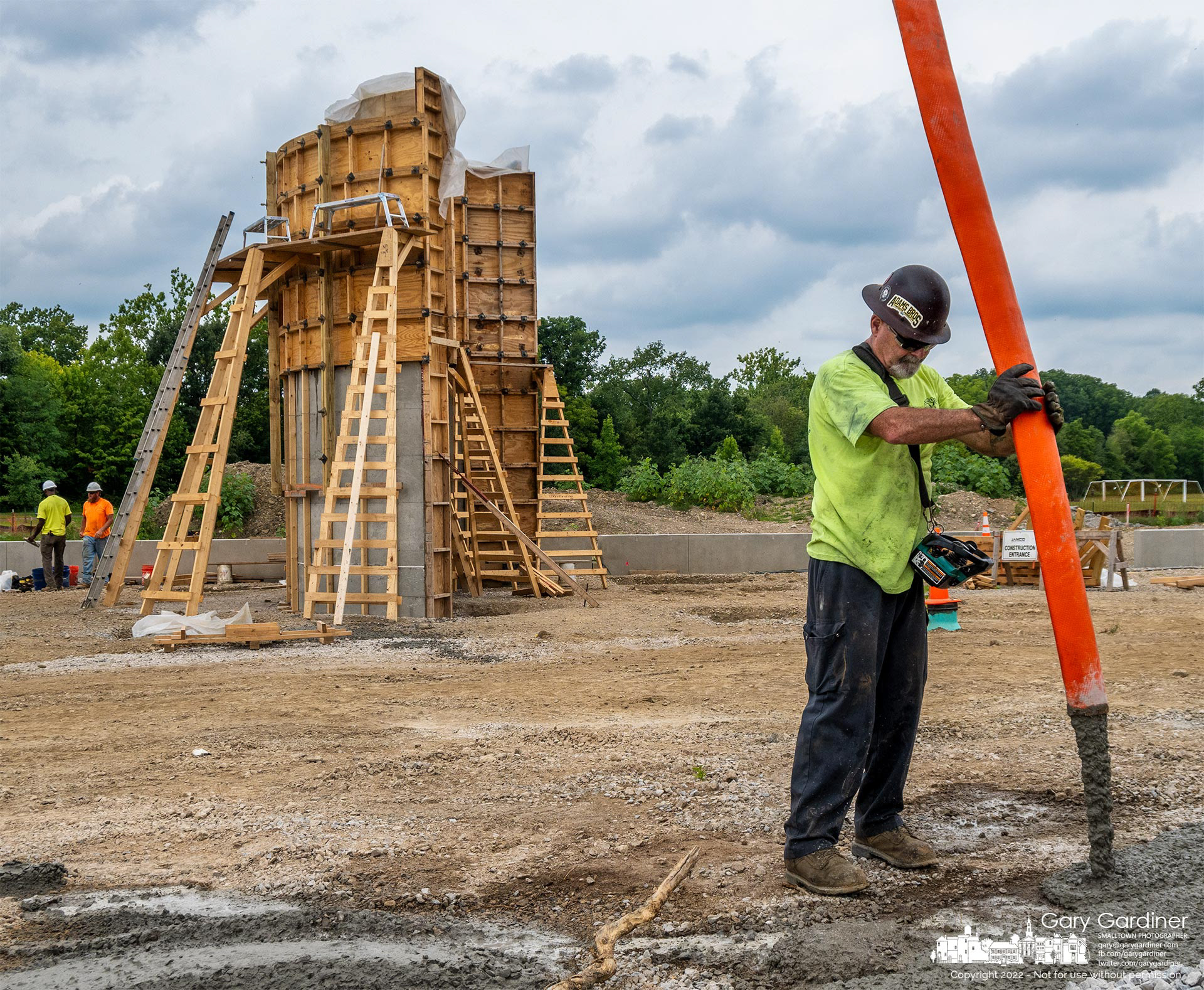 Concrete is cleared from the hose used to pump concrete into the upper section of the form, in background, that will be part of the new Veterans Memorial at the sports field across from the Community Center. My Final Photo for Aug. 4, 2022.