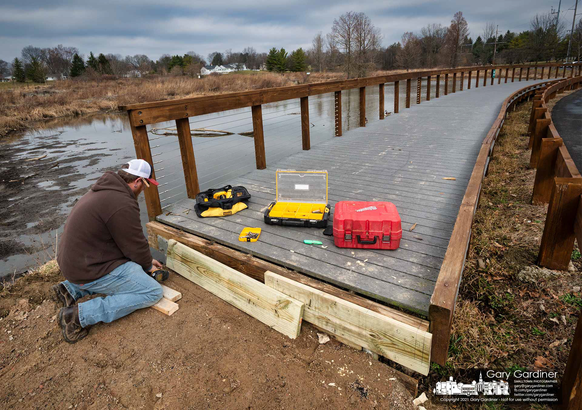 A carpenter attaches header boards to a section of the walkway at Highlands wetlands being rebuilt to create a ramp leading to the sidewalk. My Final Photo for March 16, 2021.