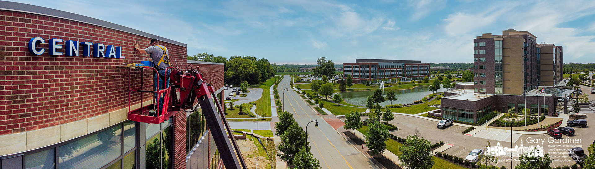 A sign-maker attaches lettering to the western edge of the top floor of the COPC office building under construction adjacent to the Renaissance Hotel and DHL Building in Westerville. My Final Photo for July 18, 2021.