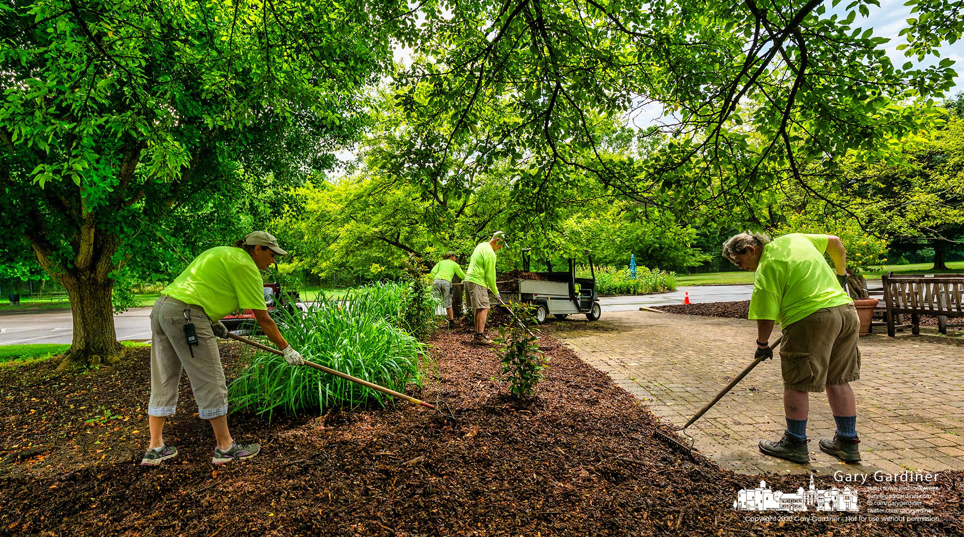 An Inniswood Metro Gardens grounds crew spreads mulch around the trees at the center of the parking lot. My Final Photo for June 18, 2021.