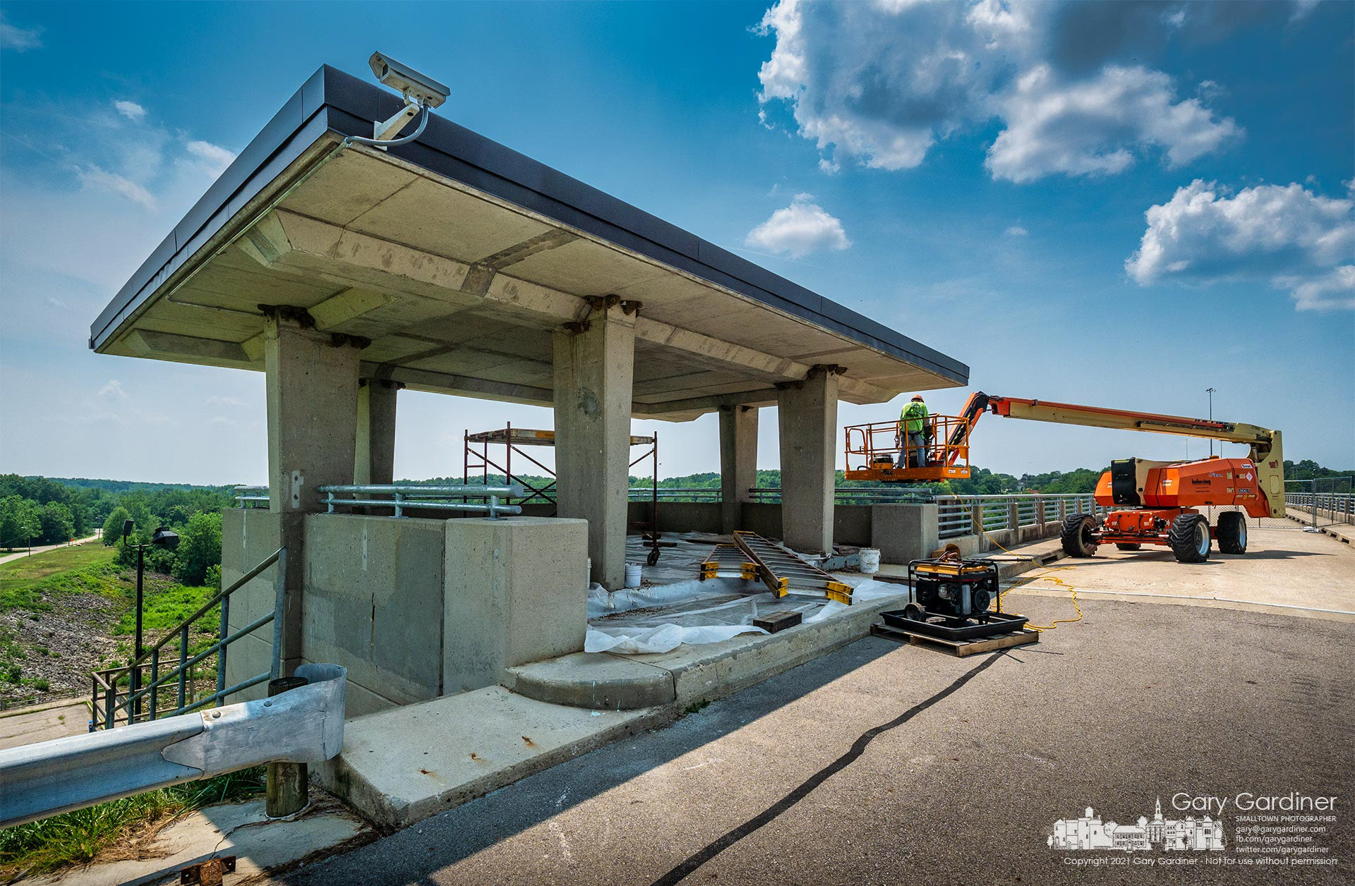 A contractor positions his lift to continue cleaning and sealing seams in the new concrete roof over the sightseeing pavilion at the eastern end of Hoover Dam. My Final Photo for July 6, 2021.