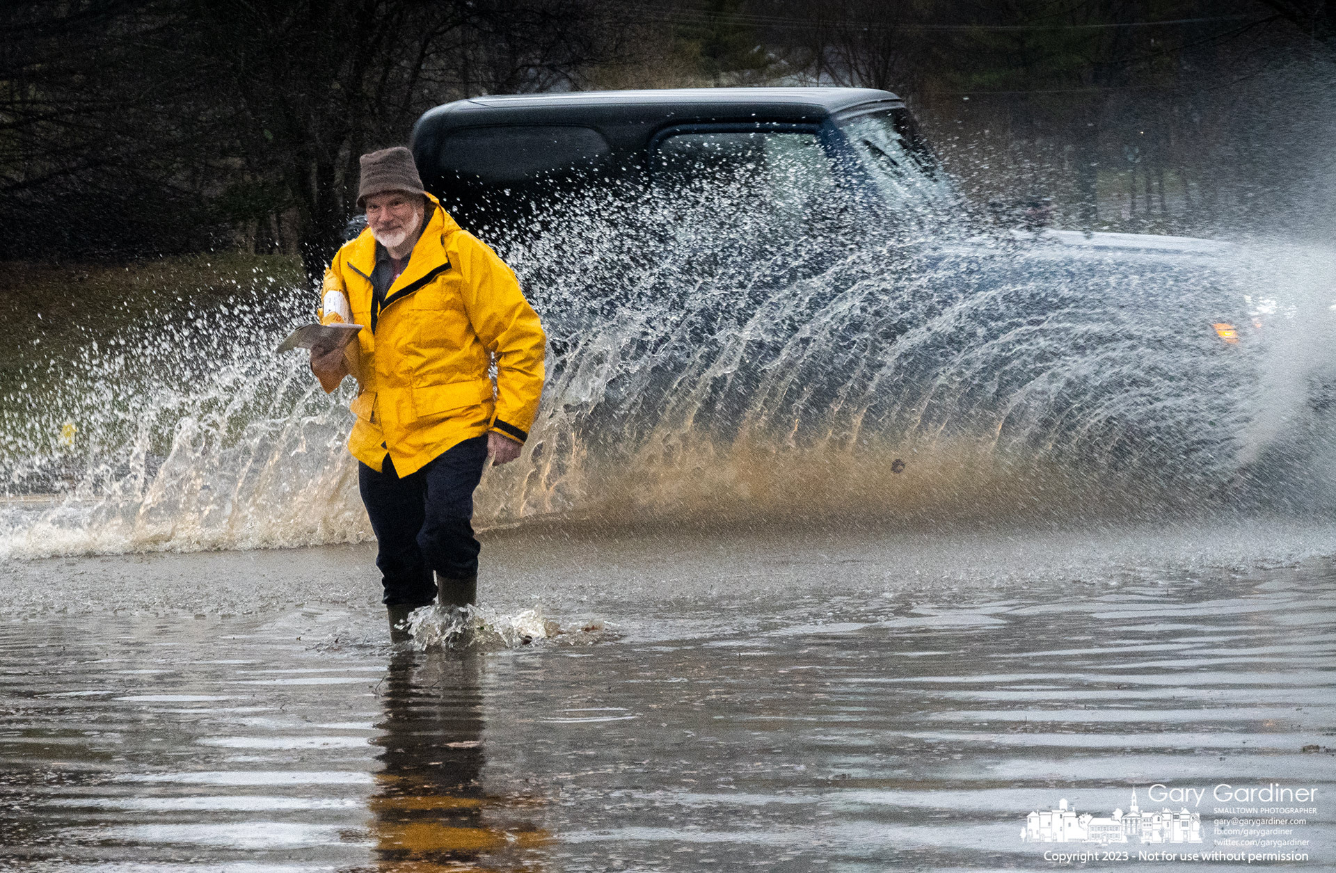Steve Herminghausen walks across partially flooded East Walnut Street and into his driveway after retrieving his mail following a day of heavy rain. My Final Photo for March 3, 2023. 