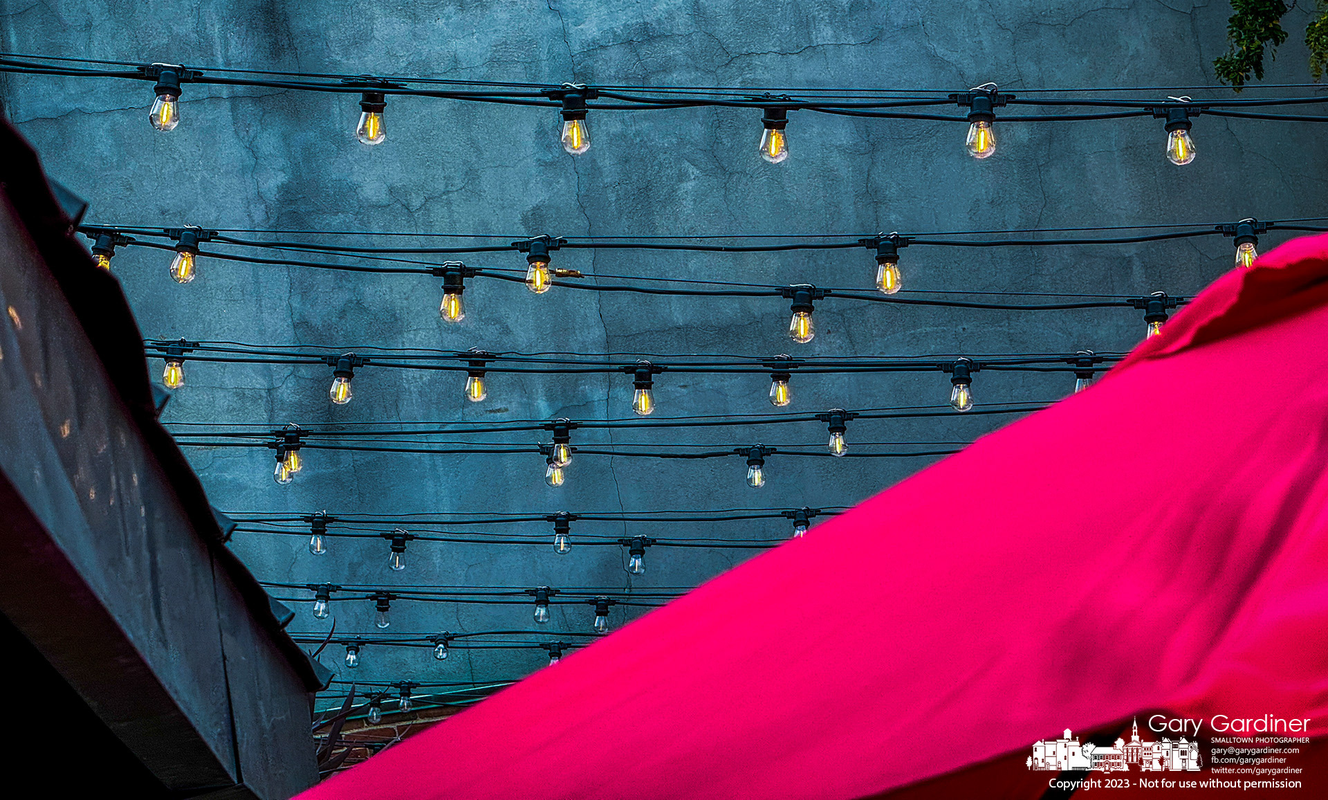 A new red umbrella, warm lights, and the blue color from an early evening sky brighten the patio at Jimmy V's in Uptown Westerville. My Final Photo for September 24, 2023.