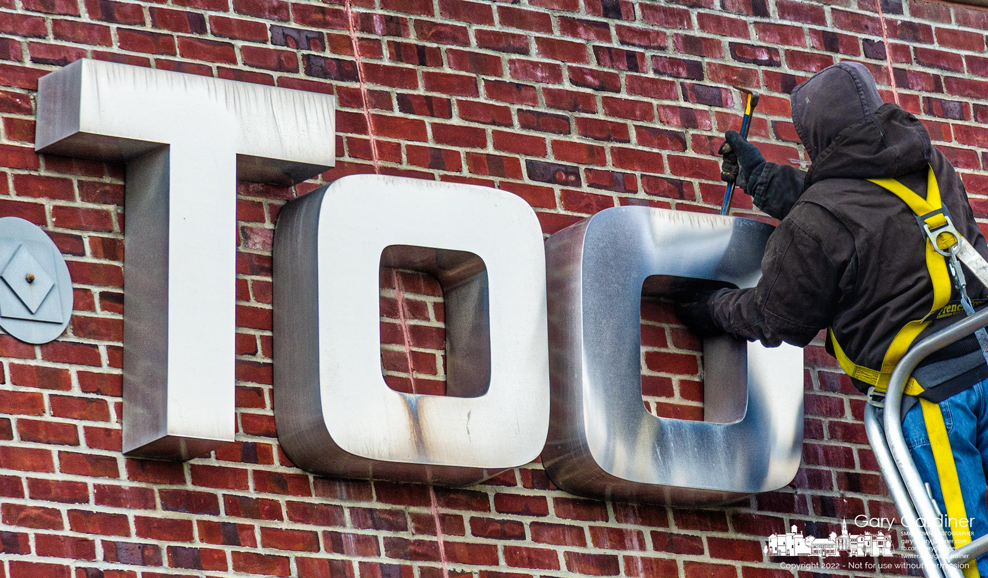 Sign company workers remove a section of the Mac Tools logo from a building on Cleveland Ave. as one of the final acts of the company's move to Dublin. My Final Photo for Feb. 14, 2022.