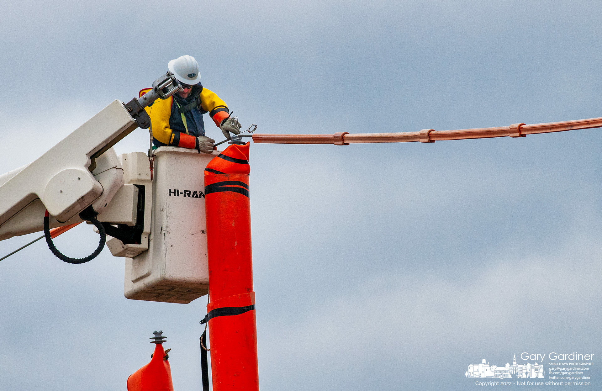 An electrician wrapped in protective gear ties off a power line to the top of a replacement utility pole on Dempsey Road. My Final Photo for Jan. 10, 2022.