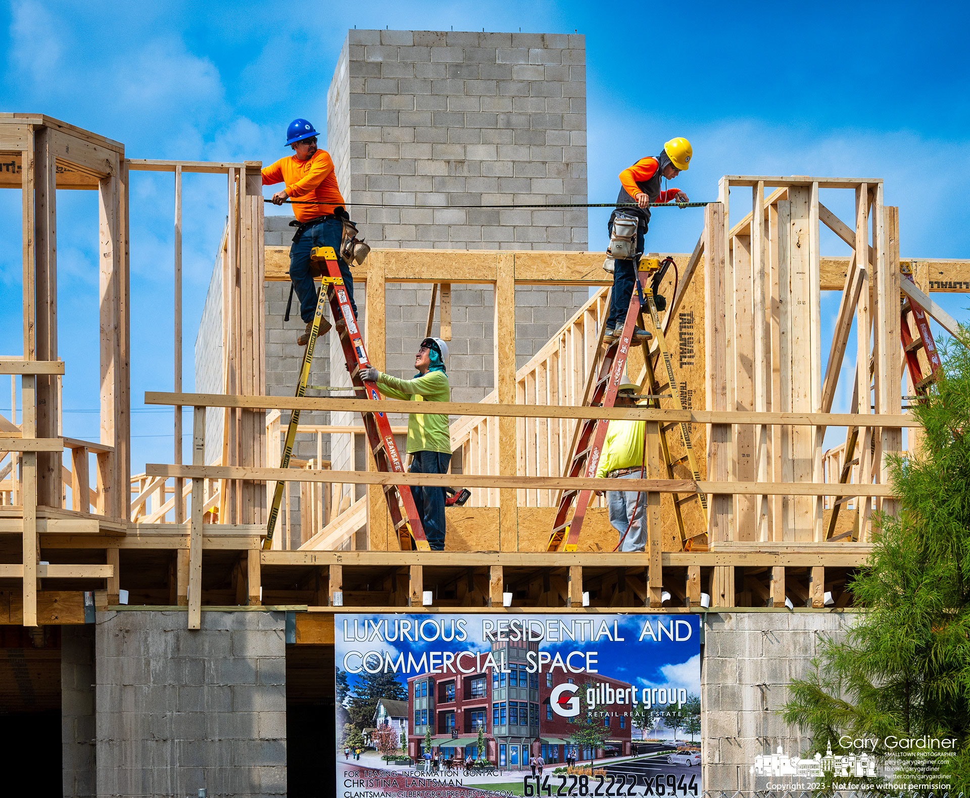 Carpenters install header boards across the second floor window of an office and apartment building being built on West College where the Book Harbor bookstore once stood in Uptown. My Final Photo for August 23, 2030. 