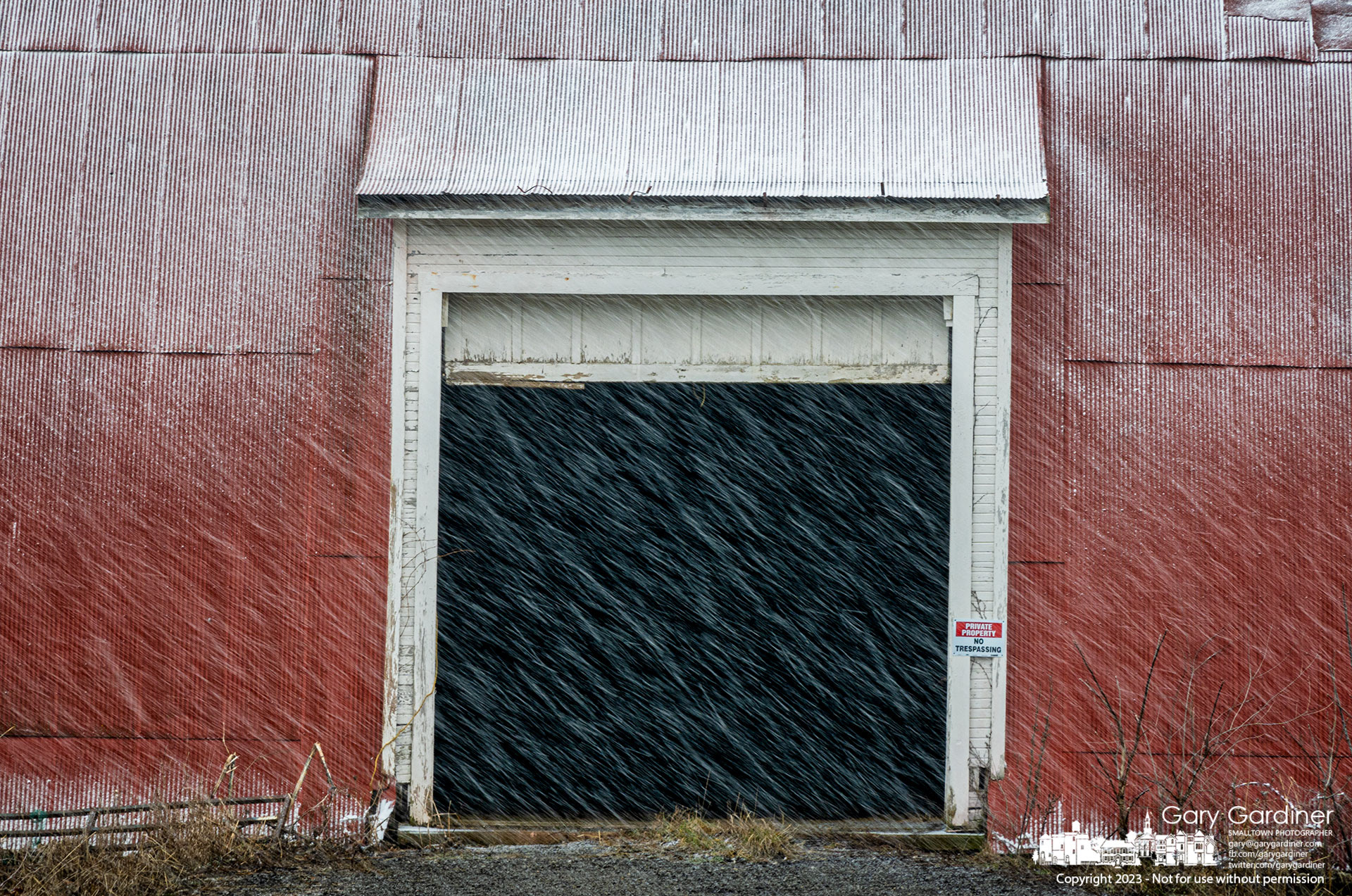 Afternoon winter snow flurries fly past the open door and begin to coat the barn at the Braun Farm. My Final Photo for January 30, 2023. 