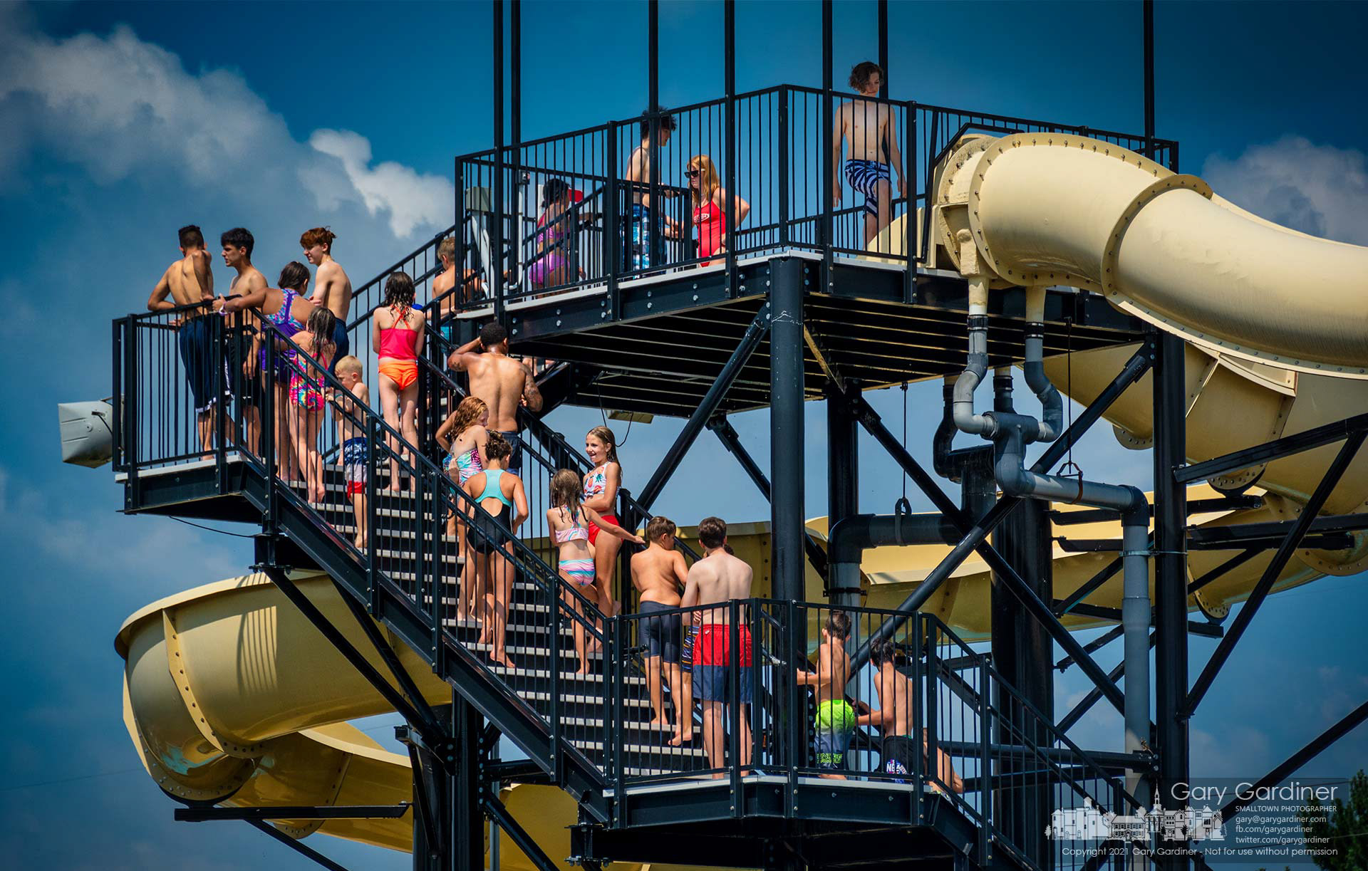 Youngsters line up on stairs leading to the two water slides at Highlands Aquatic Center hoping their time arrives for the fun ride before the pools close for 15 minutes before the hour. My Final Photo for July 18, 2021.