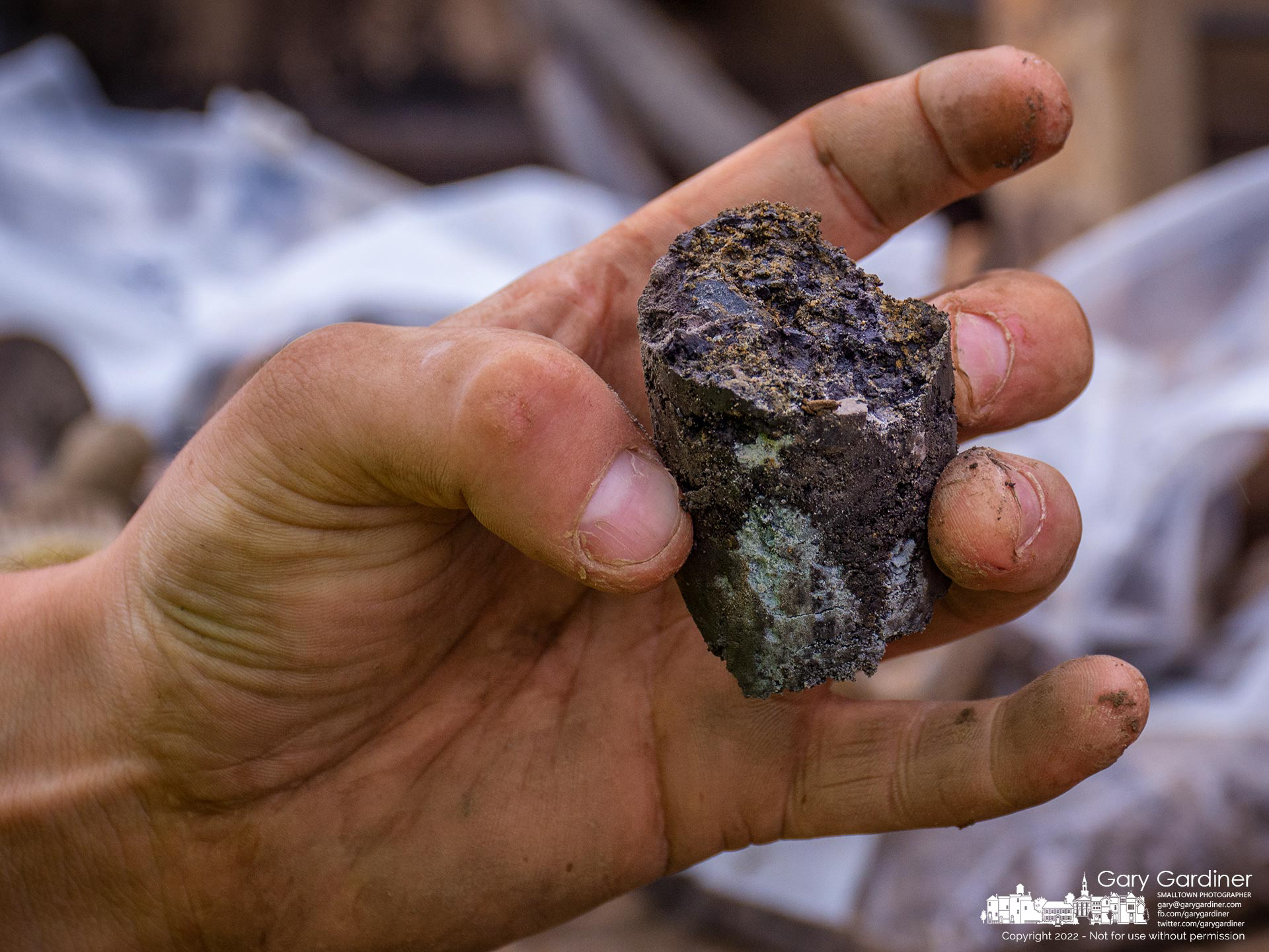 A worker examines a section of dirt and clay from a boring tool used to pull plugs of dirt from the site of what will become a car dealership on Polaris Parkway. My Final Photo for July 8, 2022.