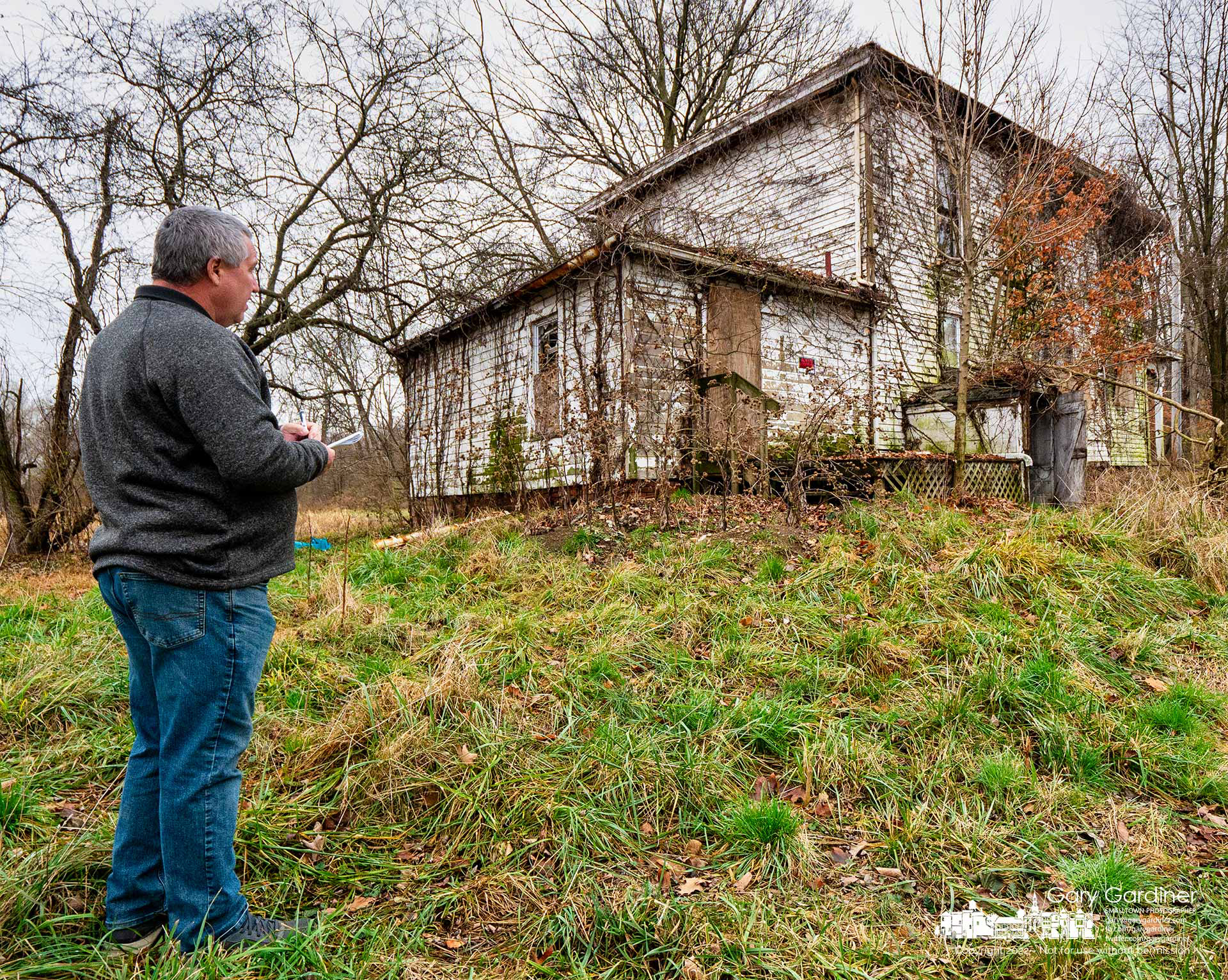 A demolition company worker figures how many truckloads of material will be hauled away when the farmhouse at the Braun Farm is demolished as the new owner plans to develop the property. My Final Photo for November 28, 2022. - https://bit.ly/3F9RCZH