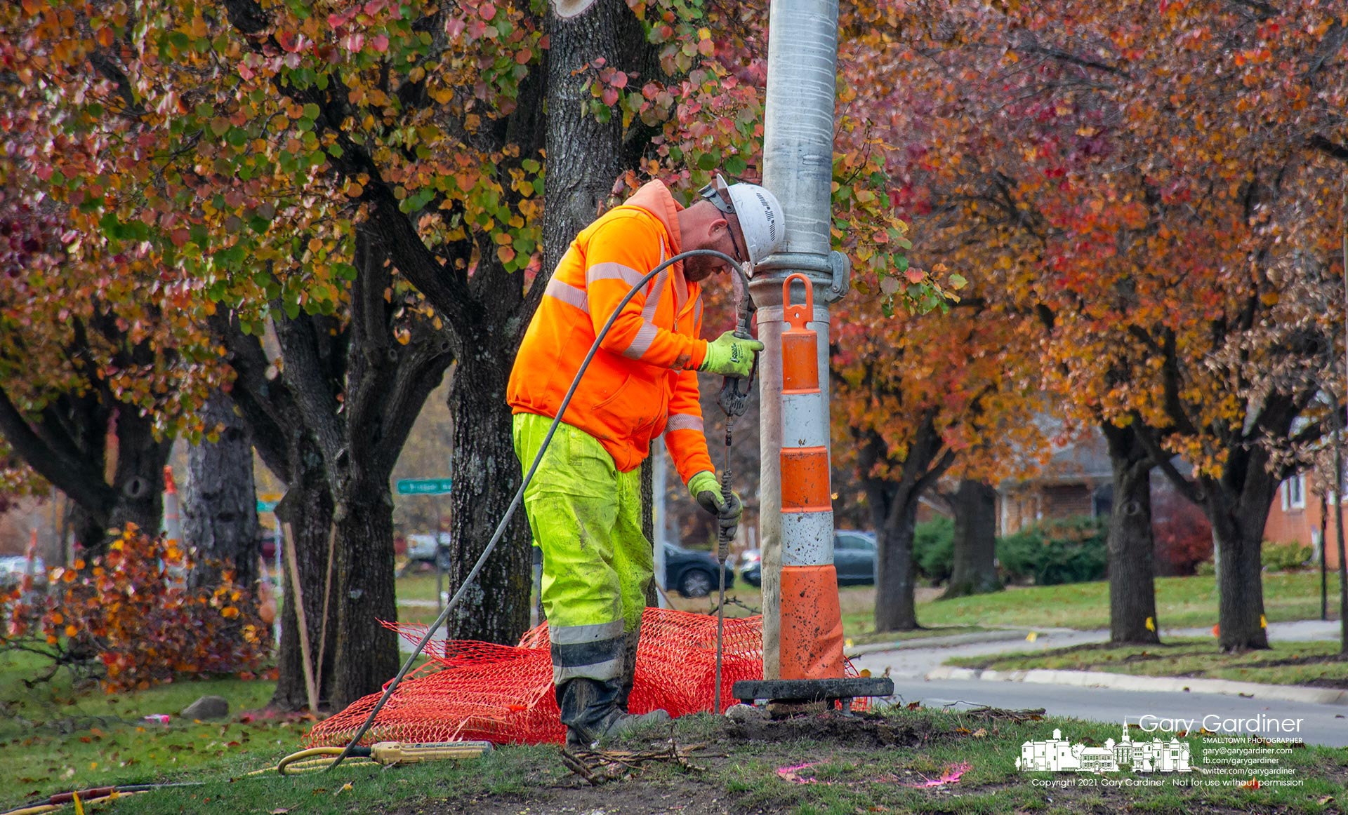A worker uses water sprayed at 4,000 psi to clear away dirt and stocks where the city plans new street lights on Huber Village Blvd. My Final Photo for Nov. 18, 2021. 