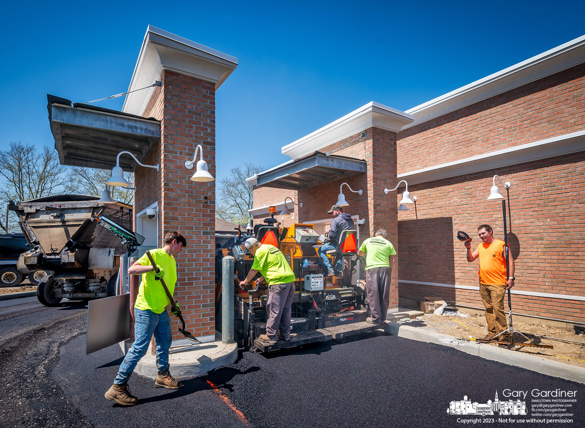 A paving company lays asphalt through one of the two drive-thru lanes at the old Flowerama at State and Schrock that is soon to open as FC Bank. My Final Photo for April 19, 2023.