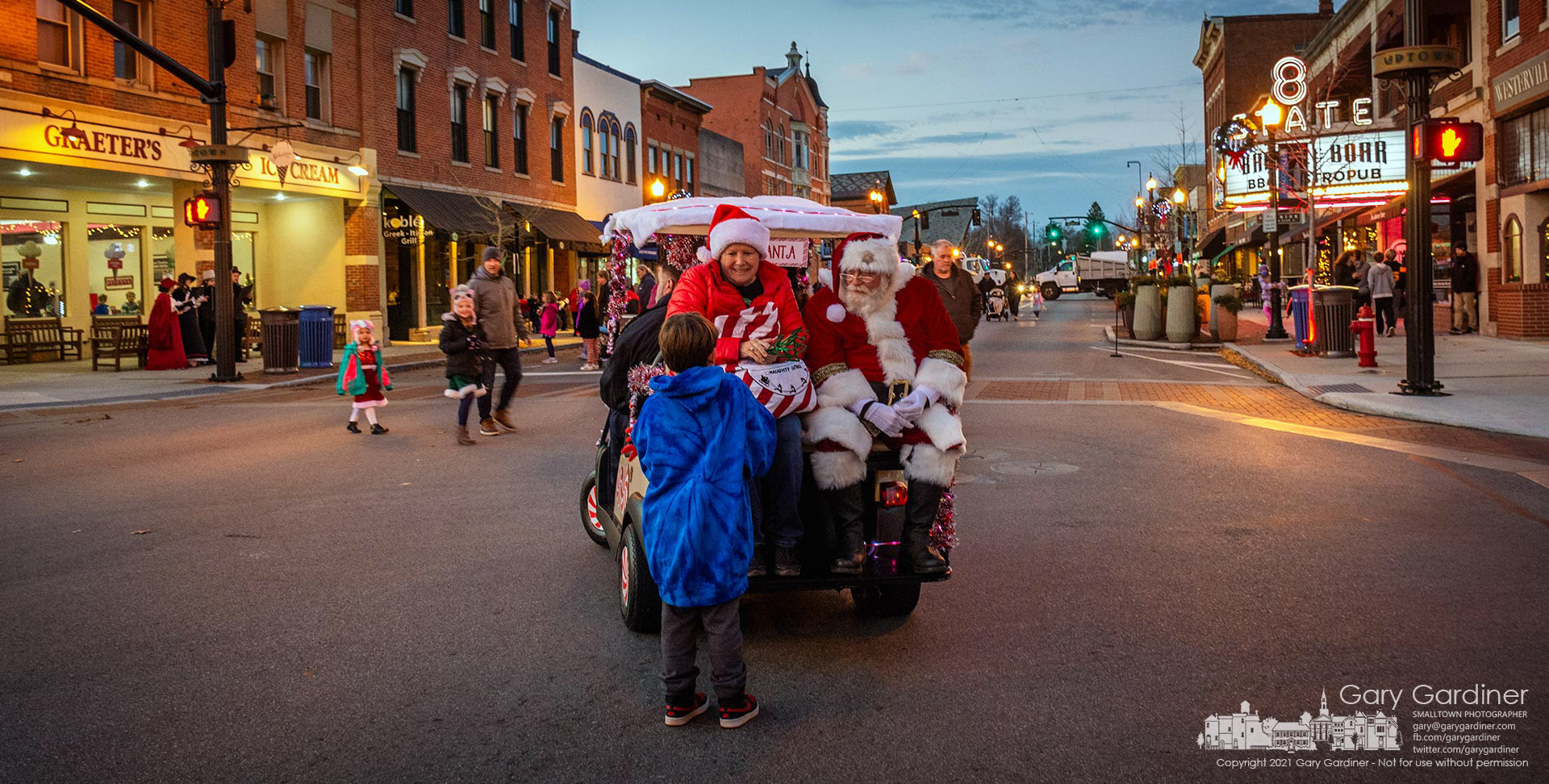 Westerville Mayor Kathy Cocuzzi accompanies Santa Claus who traveled in a golf cart instead of a sleigh driven by the police chief instead of reindeer to visit with kids and their families after the tree lighting on State Street in Uptown Westerville. My Final Photo for Dec. 3, 2021.