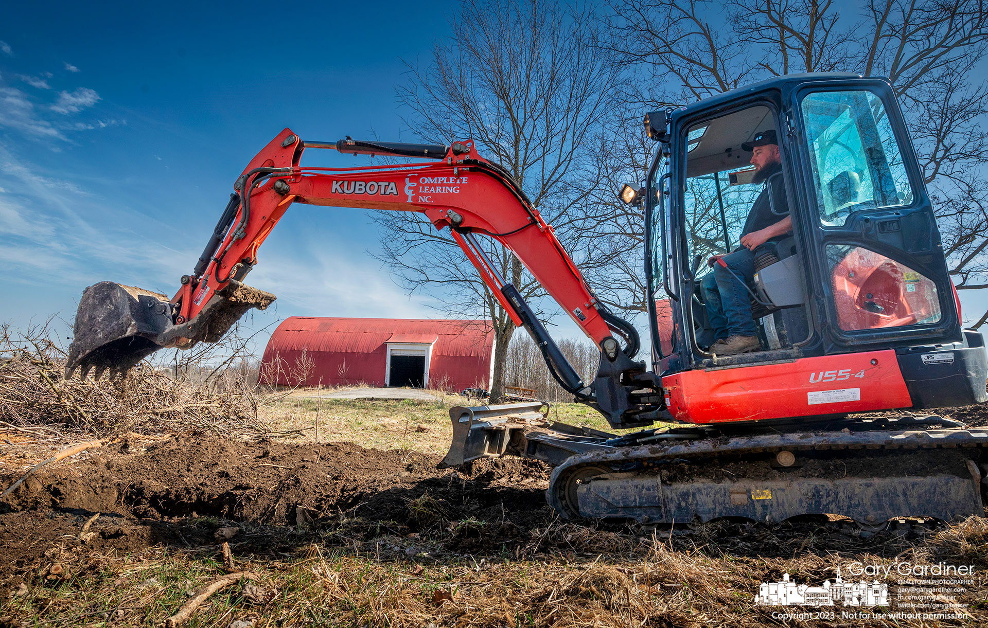 An operator fills the hole where the septic tank once stood beside the farmhouse at the Braun Farm as the action progresses on demolishing the house and barn. My Final Photo for March 1, 2023.   - https://bit.ly/3y1R0AK