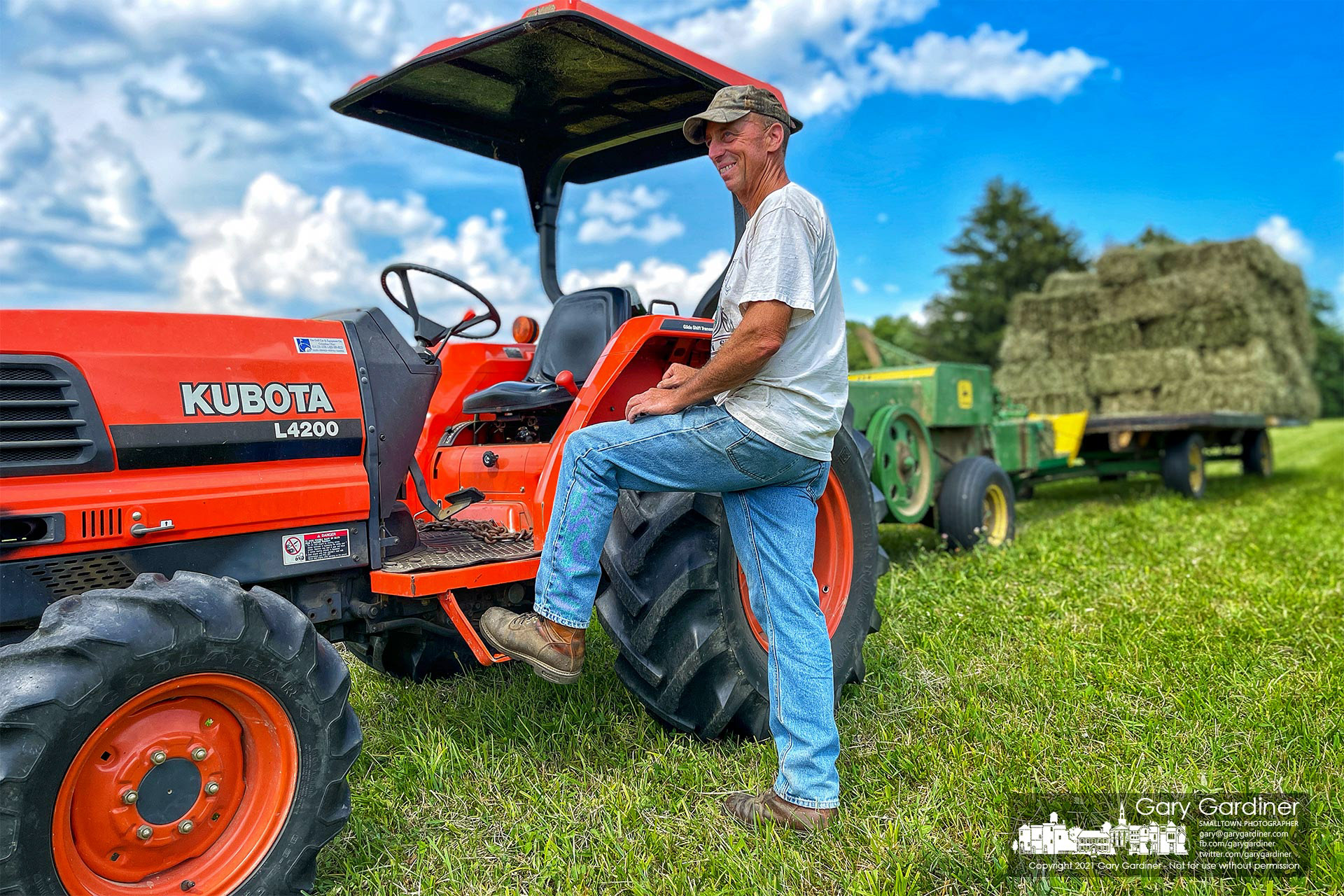 Duane Yarnell pauses before completing baling hay in the field along the edge of his farmland on County Line Road. My Final Photo for July 7, 2021.