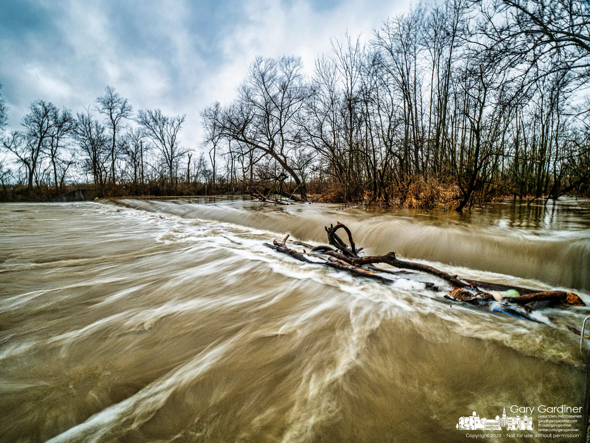 Flood stage water rushes over the Alum Creek Park North dam guided by levees built to prevent flooding along the Alum Creek corridor in Westerville. Photo for Feb. 22, 2022. 
