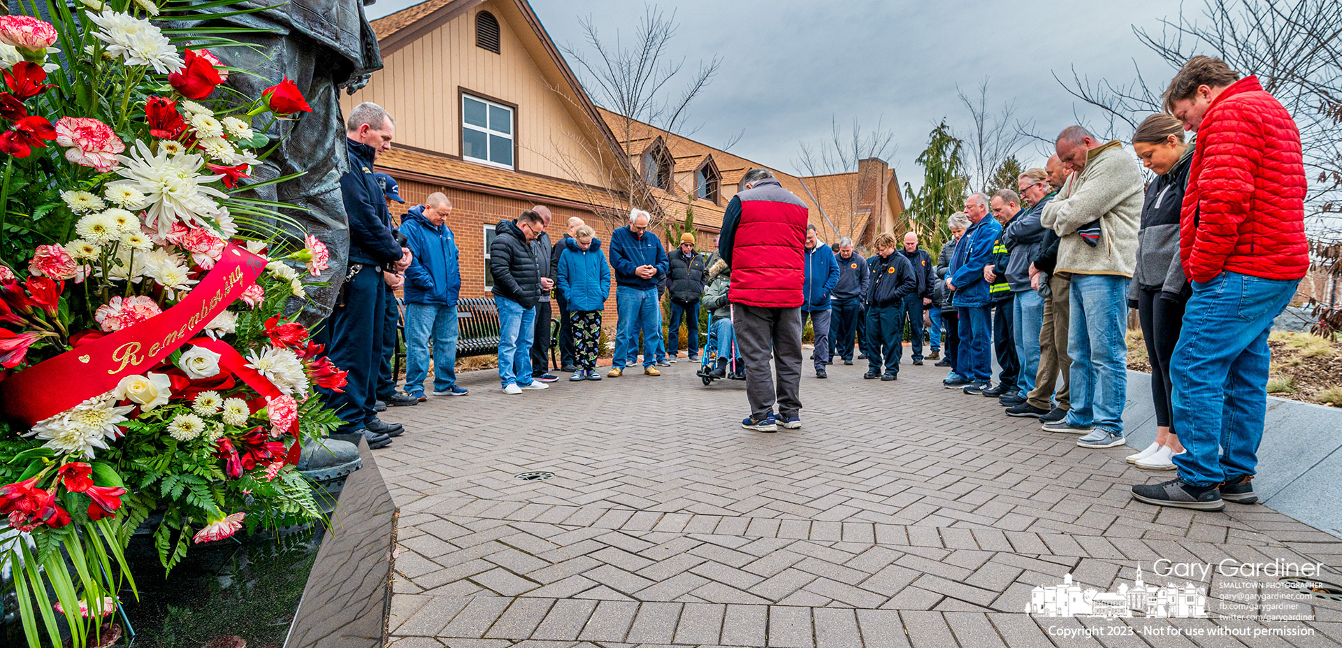 Firefighters stand in prayer at the conclusion of ceremonies beside an oversize statue at First responders Park of Westerville firefighter Dave Theisen who died 25 years again in a house fire on this date. My Final Photo for February 5, 2023. 