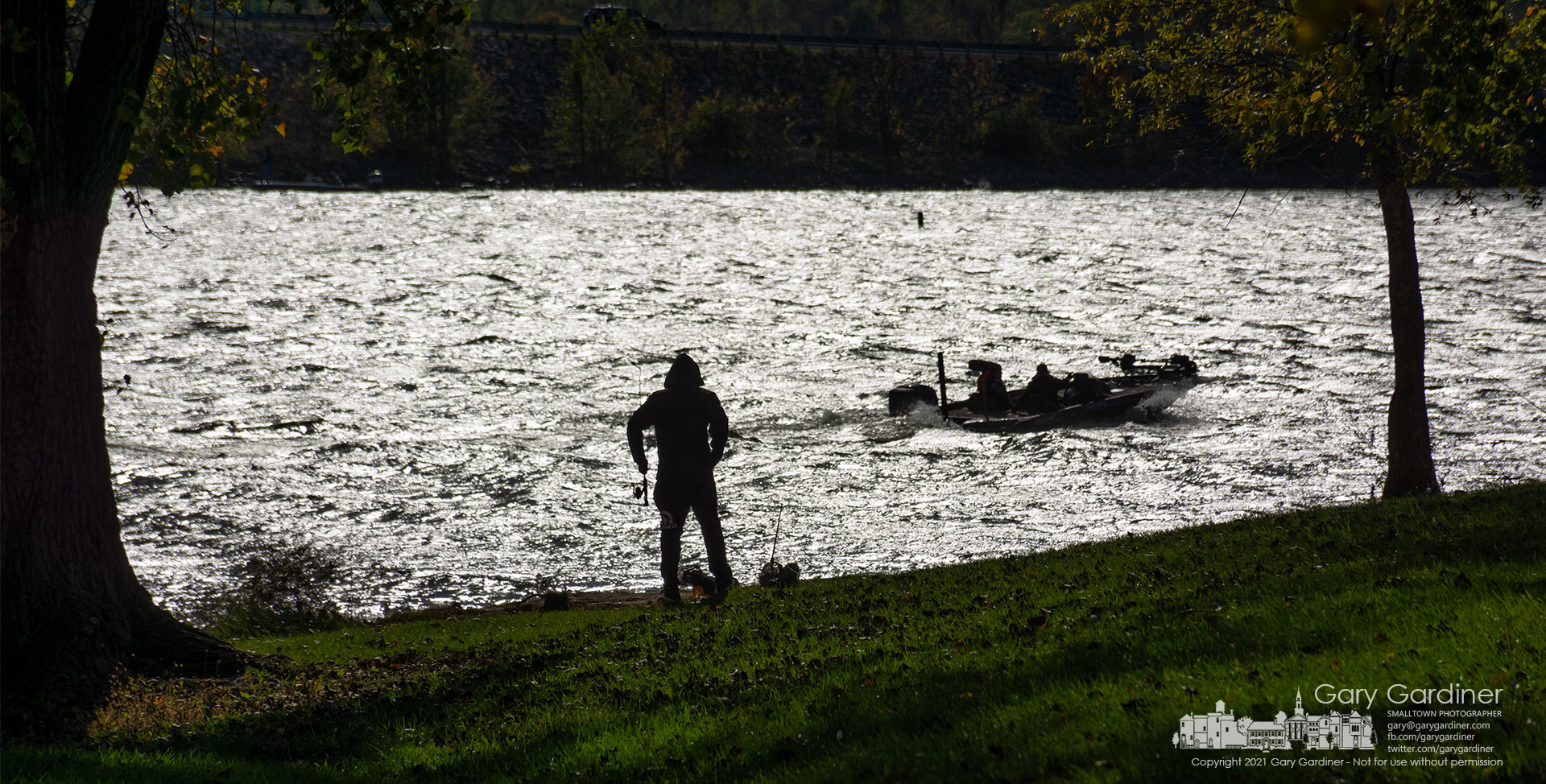 A shorebound fisherman watches as a waterborne compatriot passes by for a better fishing hole at Alum Creek State Park Lake. My Final Photo for Oct. 17, 2021.