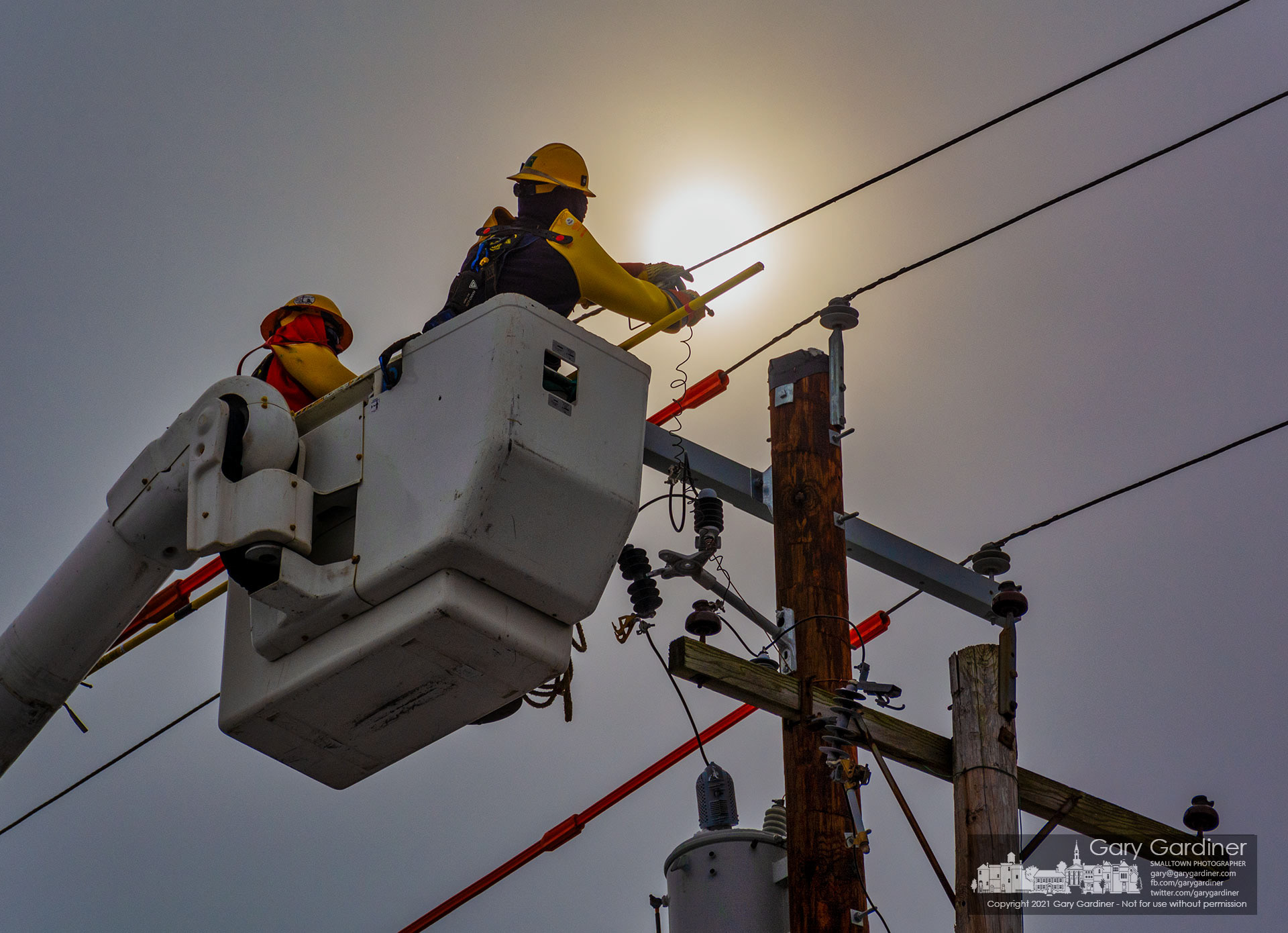 A city electric worker attaches wiring to power lines moved to a new utility pole on North State Street just north of Uptown. My Final Photo for Feb. 11, 2021.