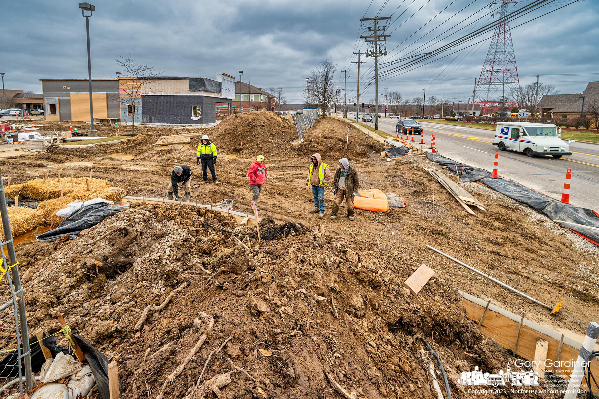 A concrete crew cleans up at the end of the day after pouring another section of the right-in right-out entrance to a new Dunkin doughnut drive-thru at Windsor Bay Shopping Center. My Final Photo for January 20, 2023. 