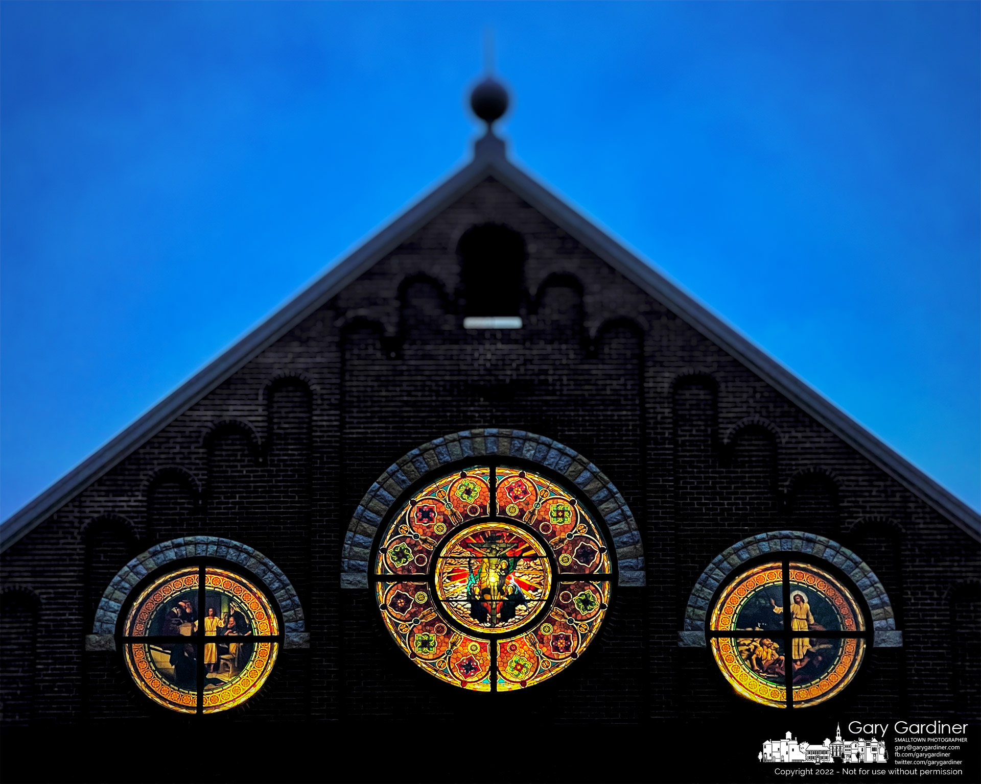The three main stained glass windows at the front of St. Paul the Apostle Catholic Church shine bright in the moments before sunrise and the first Mass of Sunday. My Final Photo for Jan. 2, 2022.