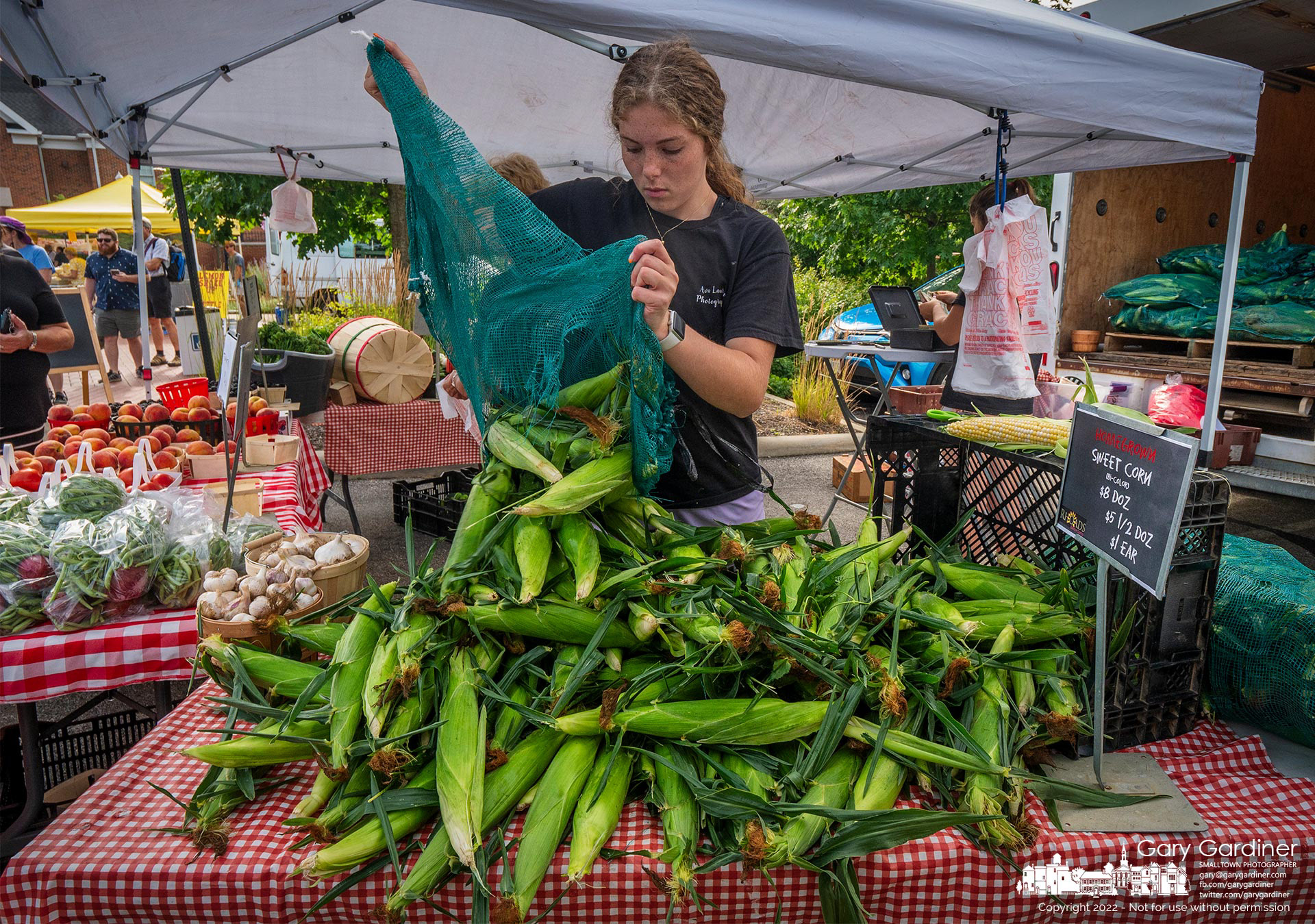 First of the season fresh corn is dumped on a table at the Rhoads Farm tent bringing another summer vegetable feast item to the Saturday Farmer’s Market. My Final Photo for July 9, 2022.
