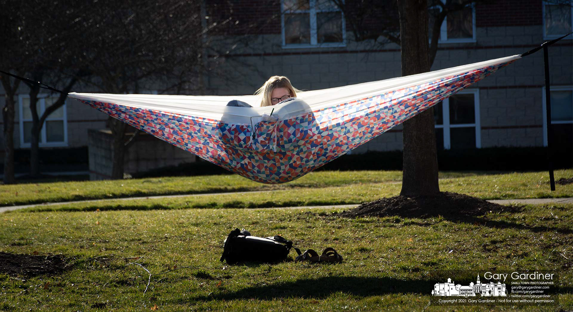 An Otterbein student reads in a hammock with her back warmed by the afternoon sun on the grassy plaza behind Towers hall. My Final Photo for March 6, 2021.