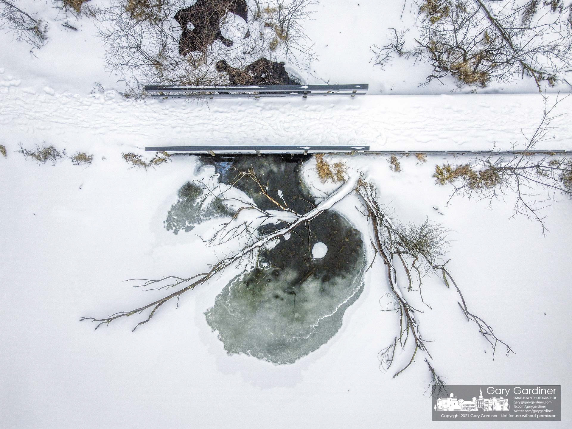 The small stream feeding into Boyer Nature Preserve beneath a portion of the raised walkway blends into the frozen waters of the wetlands. My Final Photo for Feb. 18, 2021.