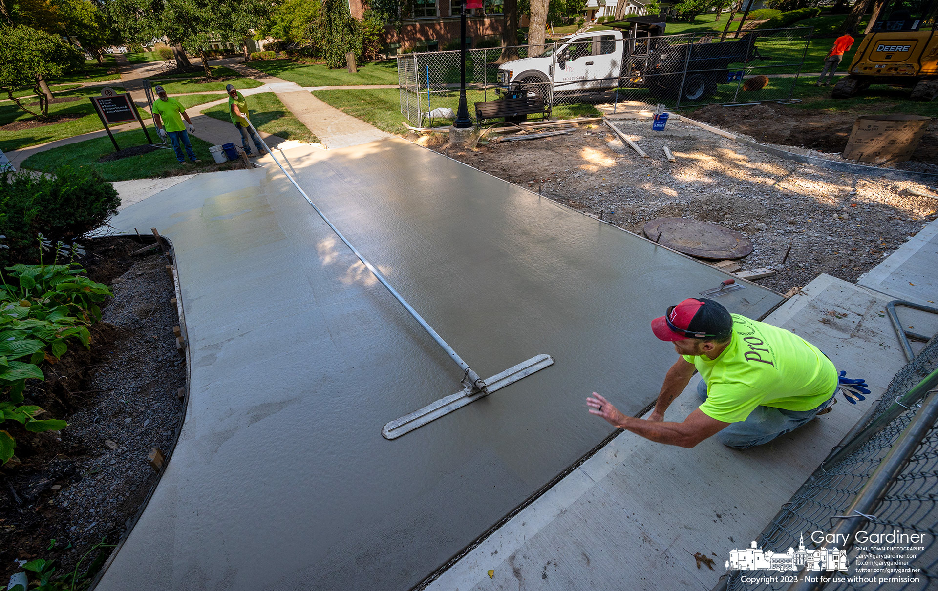 A contractor signals as a bull float levels a large section of concrete sidewalk poured at Towers Hall on the Otterbein University campus where repairs to old and damaged high-pressure steam pipes was recently completed. My Final Photo for August 28, 2023.