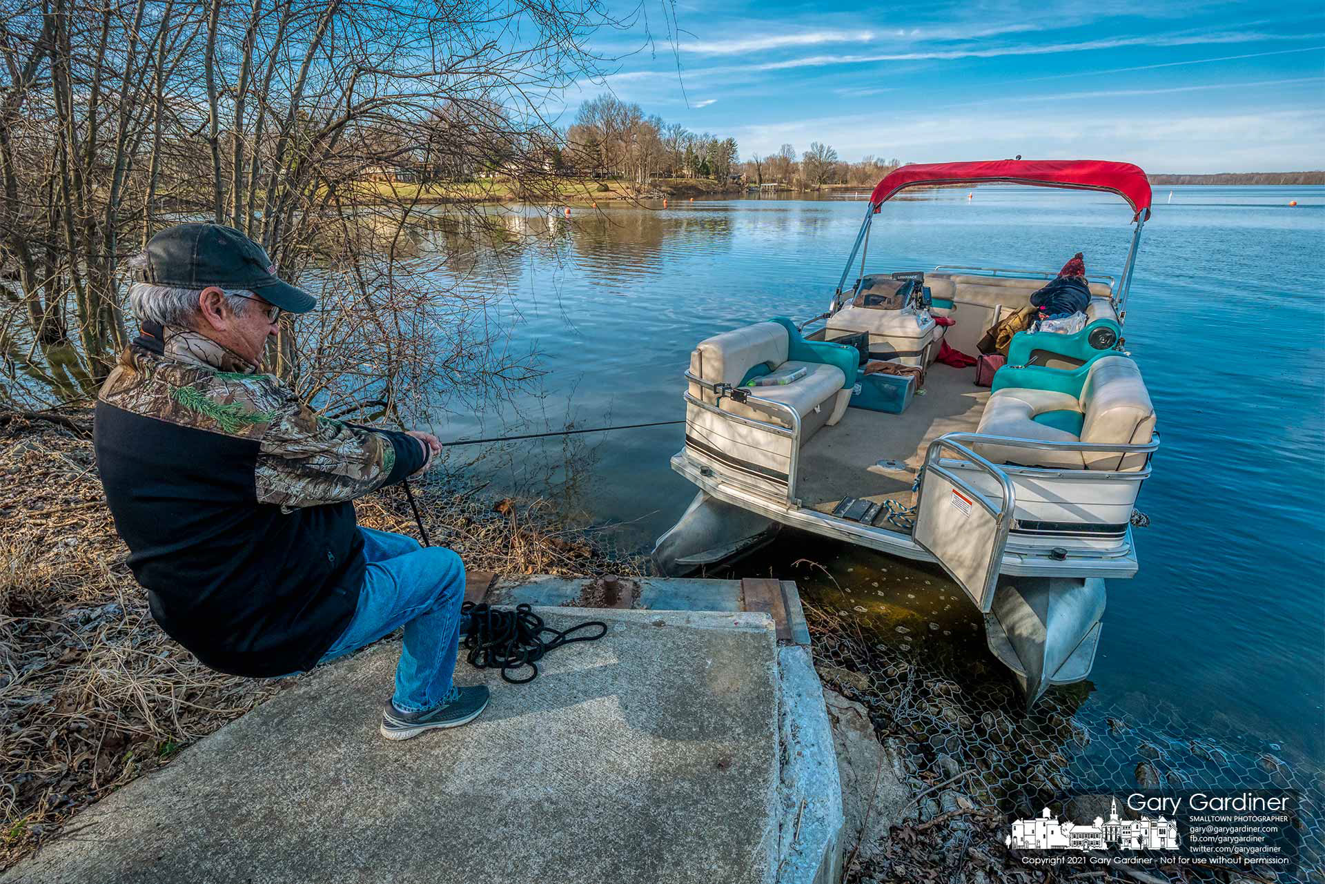A boater pulls his pontoon boat close to shore for a temporary morning for passenger offload after completing a test run putting hours on a new motor for the craft. My Final Photo for March 13, 2021. 