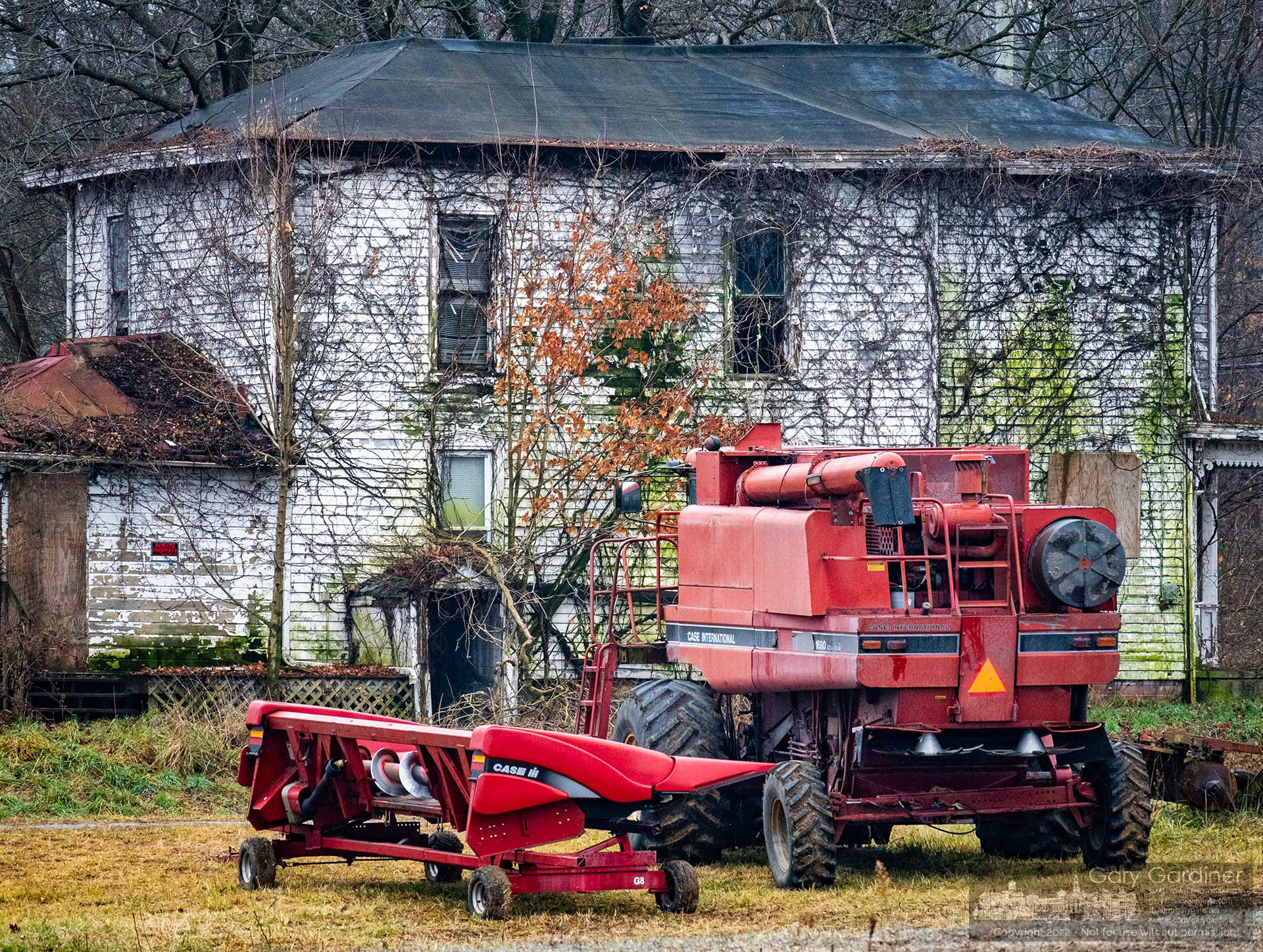 A combine with its corn harvester head removed at the completion of the season's harvest sits on the open ground beside the old farmhouse at the Braun Farm where the owners plan to demolish the house and barn to make way for a mixed-use development on the land along Cleveland Ave. and Cooper Road. My Final Photo for December 7, 2022.