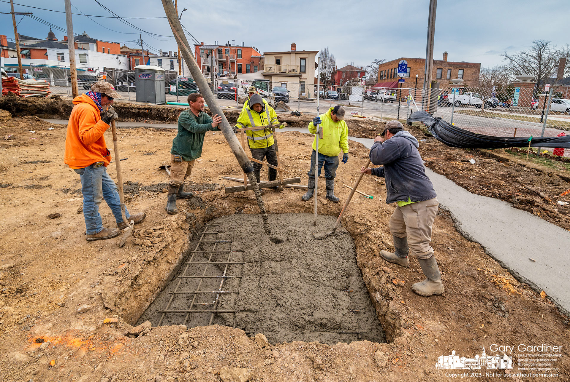 A work crew pours footers for a three-story tall office/apartment building with parking on West College where the Book Harbour once stood. My Final Photo for February 7, 2023. 