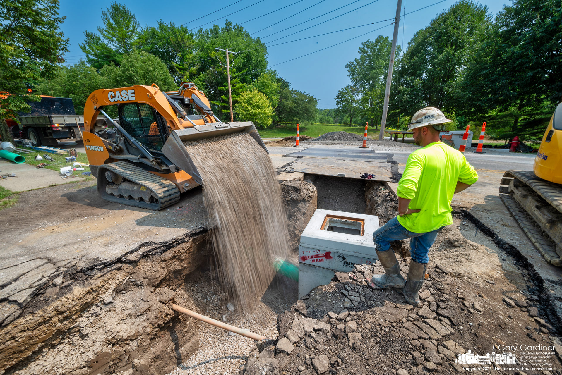 Gravel is poured into the trench where new storm drains connect to a system of drains that will move water from flooded sections of East Walnut Street to the wetlands at Highland Park. My Final Photo for August 2, 2023. 