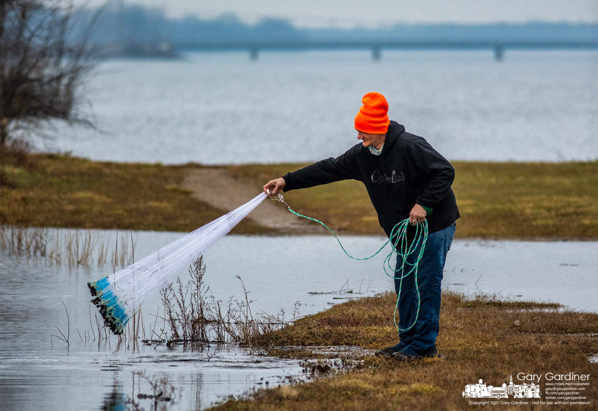 A fisherman cleans his cast net after several attempts to catch baitfish in the high waters that flowed over sections of the walkway near the Hoover Reservoir dam. My Final Photo for Dec. 27, 2021.