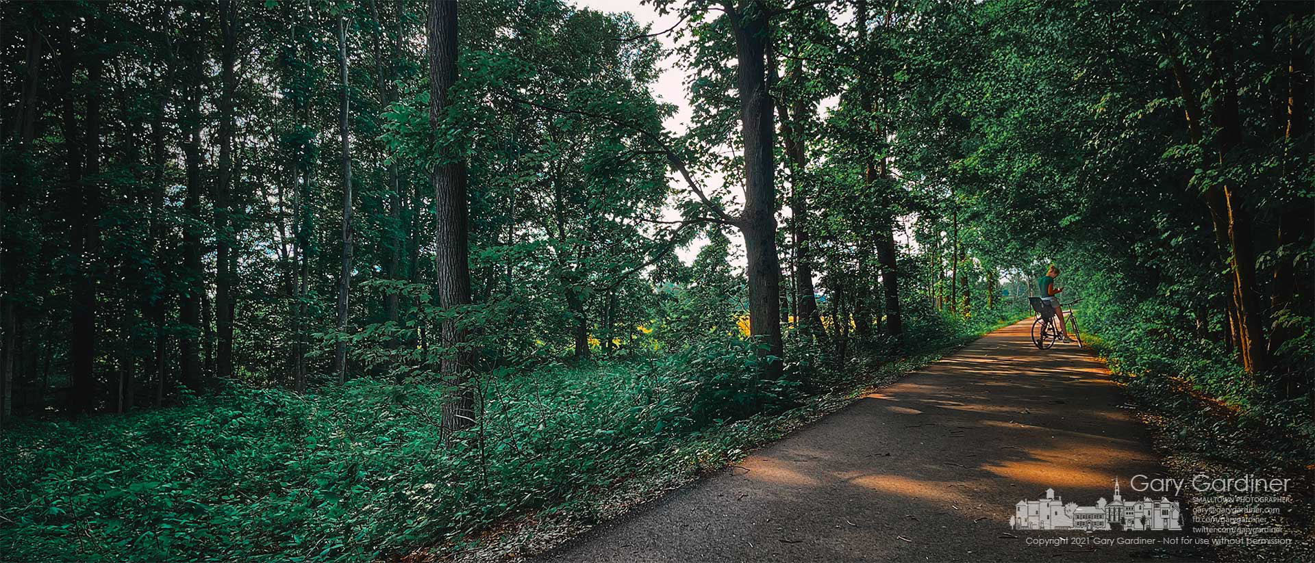 A woman pauses on the T.J. Evans bike trail from Johnstown to Newark to check her phone before completing her ride Saturday afternoon. My Final Photo for June 26, 2021.