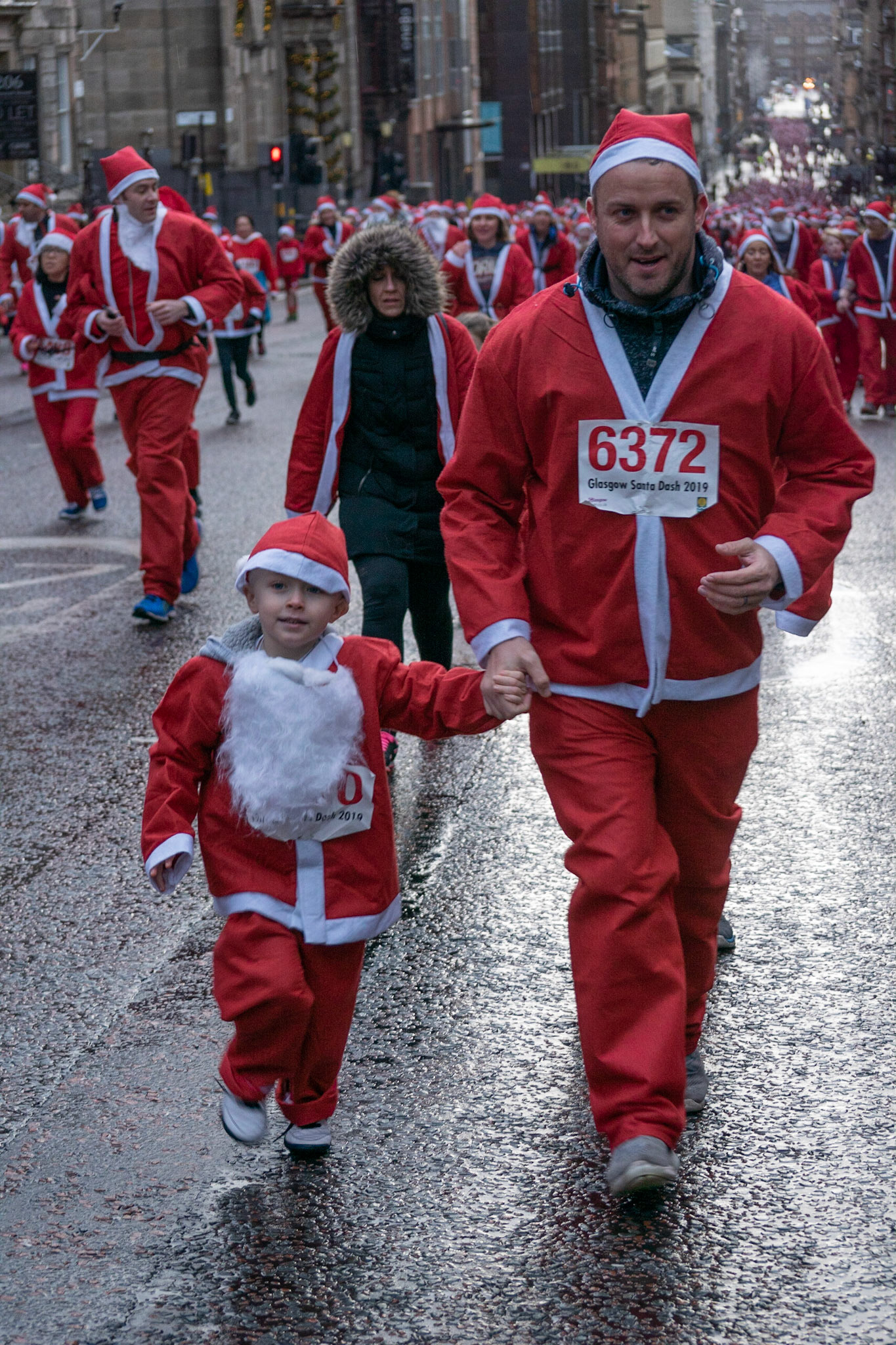Glasgow, Scotland, 8th December 2019. The annual 5K Santa Dash from George Square with approximately 8000 people dressed as Santa running in the rain and raising money for charity. Credit: Richard Gass/Alamy Live News
