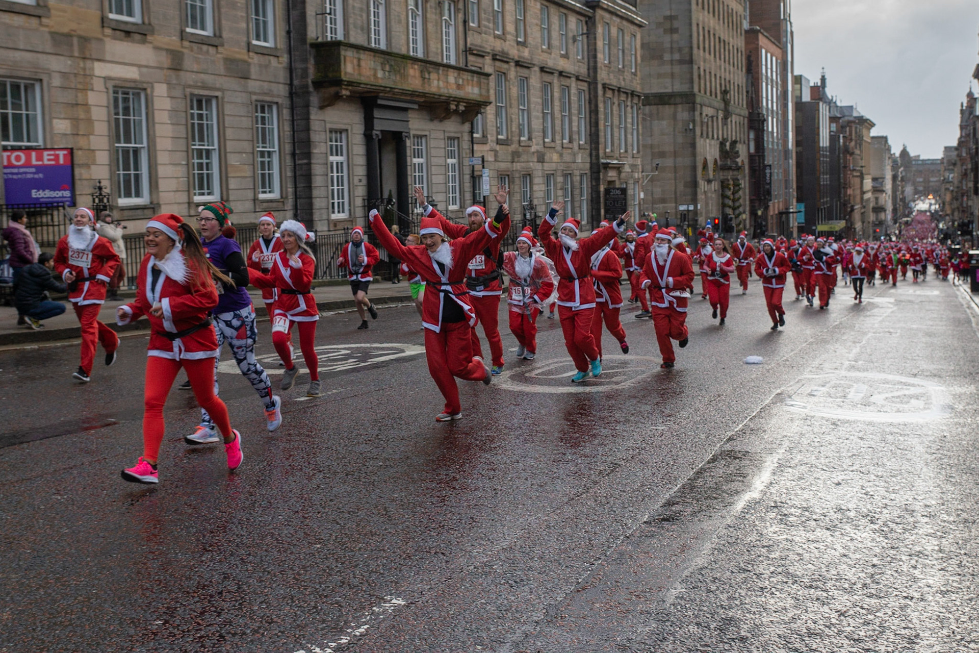 Glasgow, Scotland, 8th December 2019. The annual 5K Santa Dash from George Square with approximately 8000 people dressed as Santa running in the rain and raising money for charity. Credit: Richard Gass/Alamy Live News
