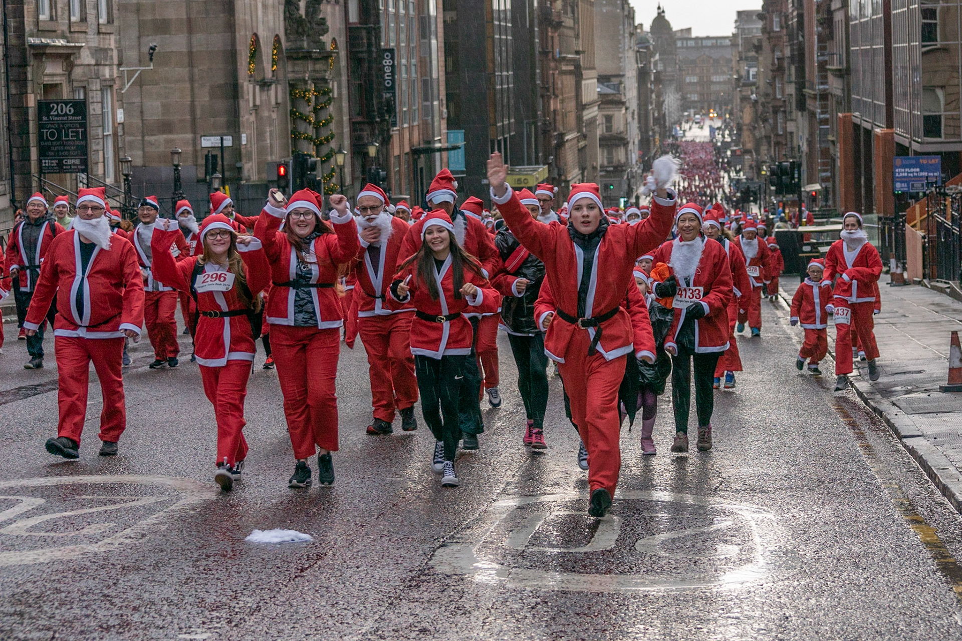 Glasgow, Scotland, 8th December 2019. The annual 5K Santa Dash from George Square with approximately 8000 people dressed as Santa running in the rain and raising money for charity. Credit: Richard Gass/Alamy Live News