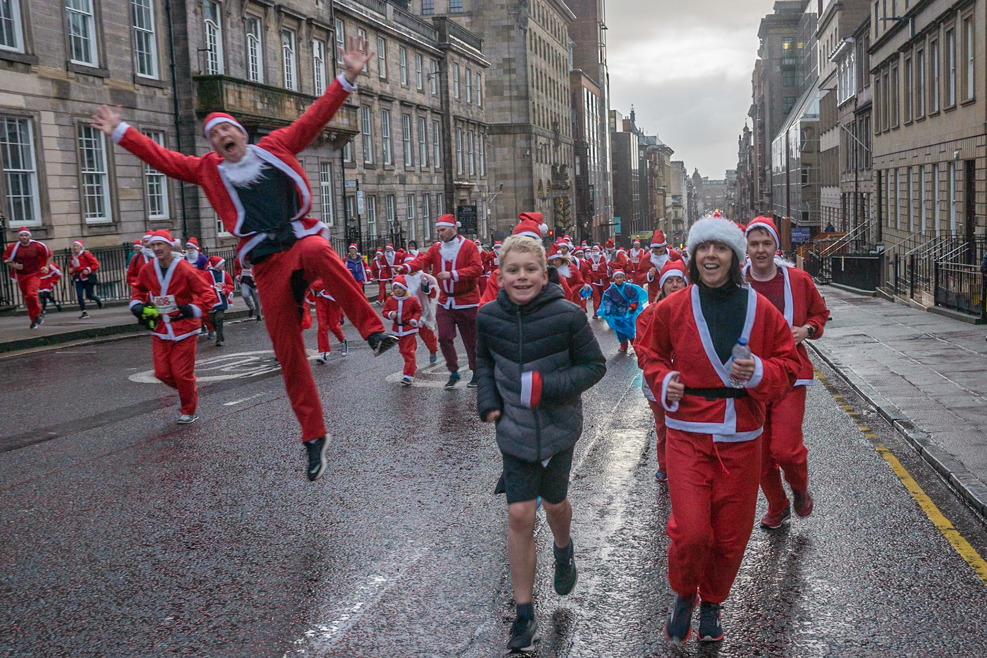 Glasgow, Scotland, 8th December 2019. The annual 5K Santa Dash from George Square with approximately 8000 people dressed as Santa running in the rain and raising money for charity. Credit: Richard Gass/Alamy Live News
