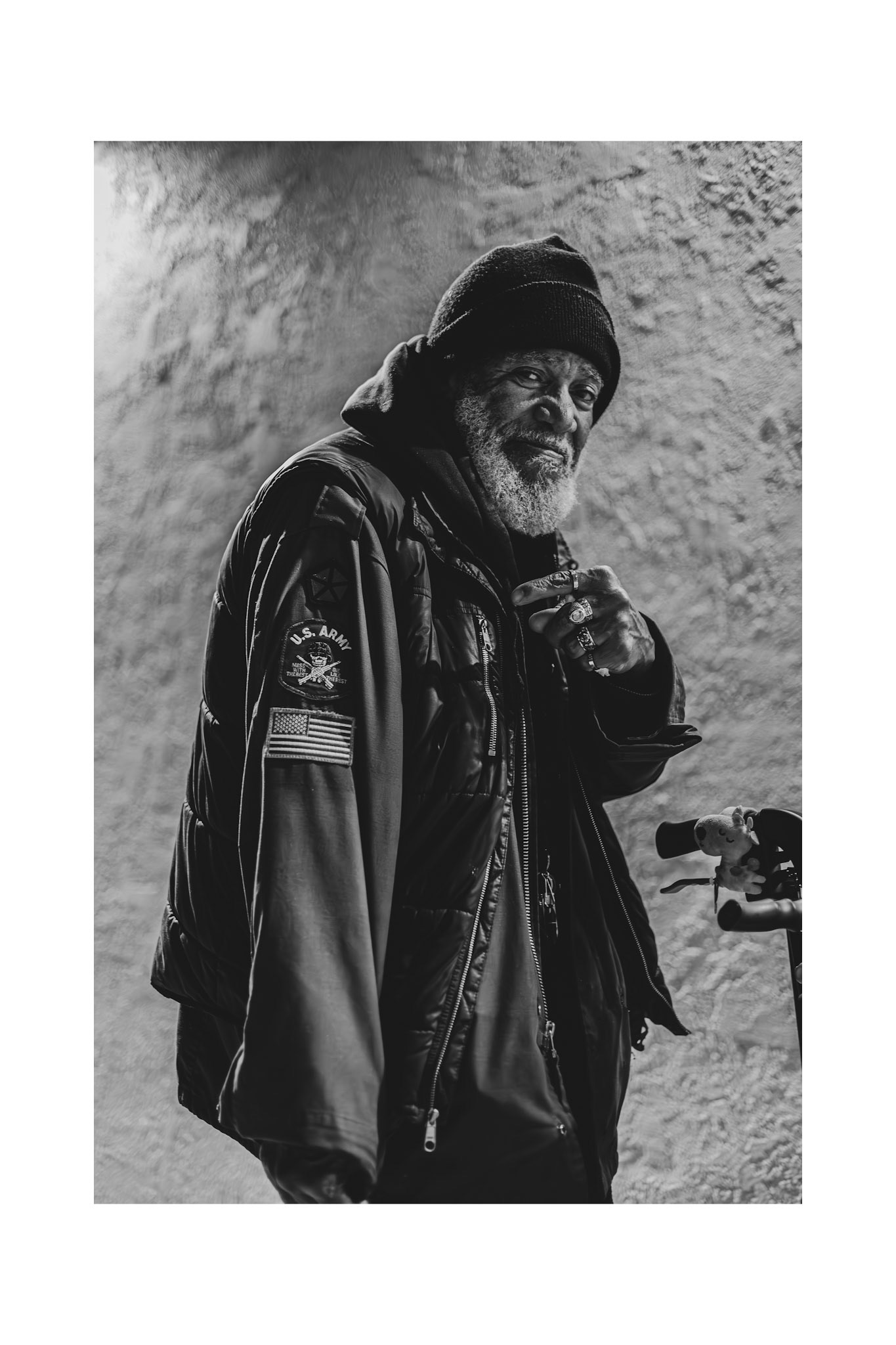 Vietnam Veteran Darrell poses in front of liquor store pointing to his Military patch, El Monte, Ca, 2014