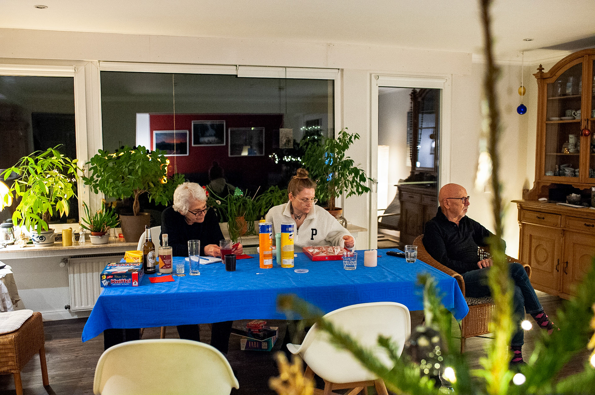 Ann-Kristin and mom open an advent calendar she received as a gift at a furniture store on New Year’s Eve. Dad watches tv. Oberhausen, Germany, December 31, 2022.