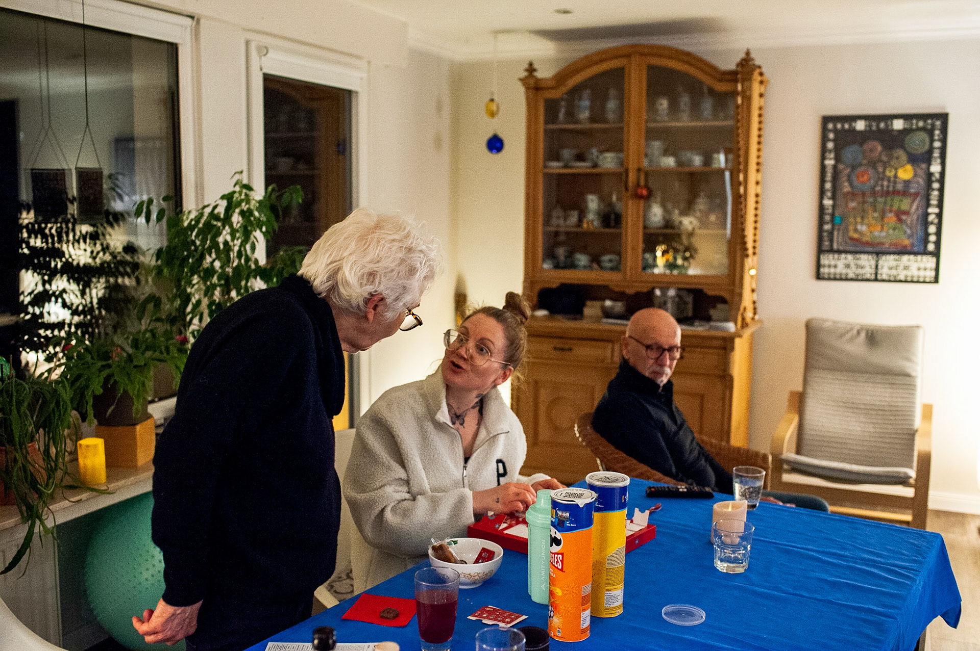 Ann-Kristin and mom open an advent calendar she received as a gift at a furniture store on New Year’s Eve. Dad watches tv. Oberhausen, Germany, December 31, 2022.