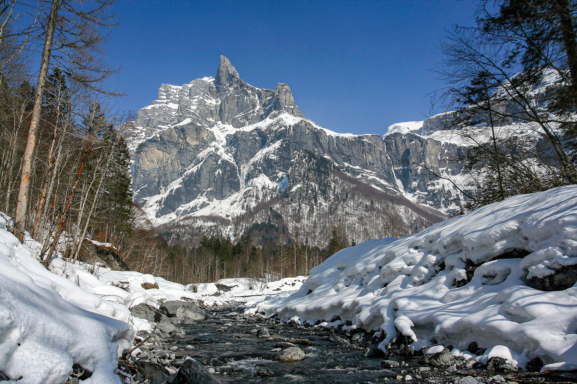 Le torrent du Giffre. Rochers enneigés. Au fond, le Pic de Tenneverge (2959m). Cirque du Fer-à-cheval. Haute-Savoie