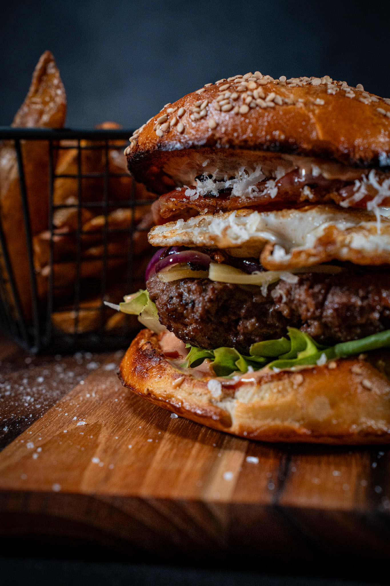 Gourmet Burger Stack – Juicy double cheeseburger with fries in moody lighting.