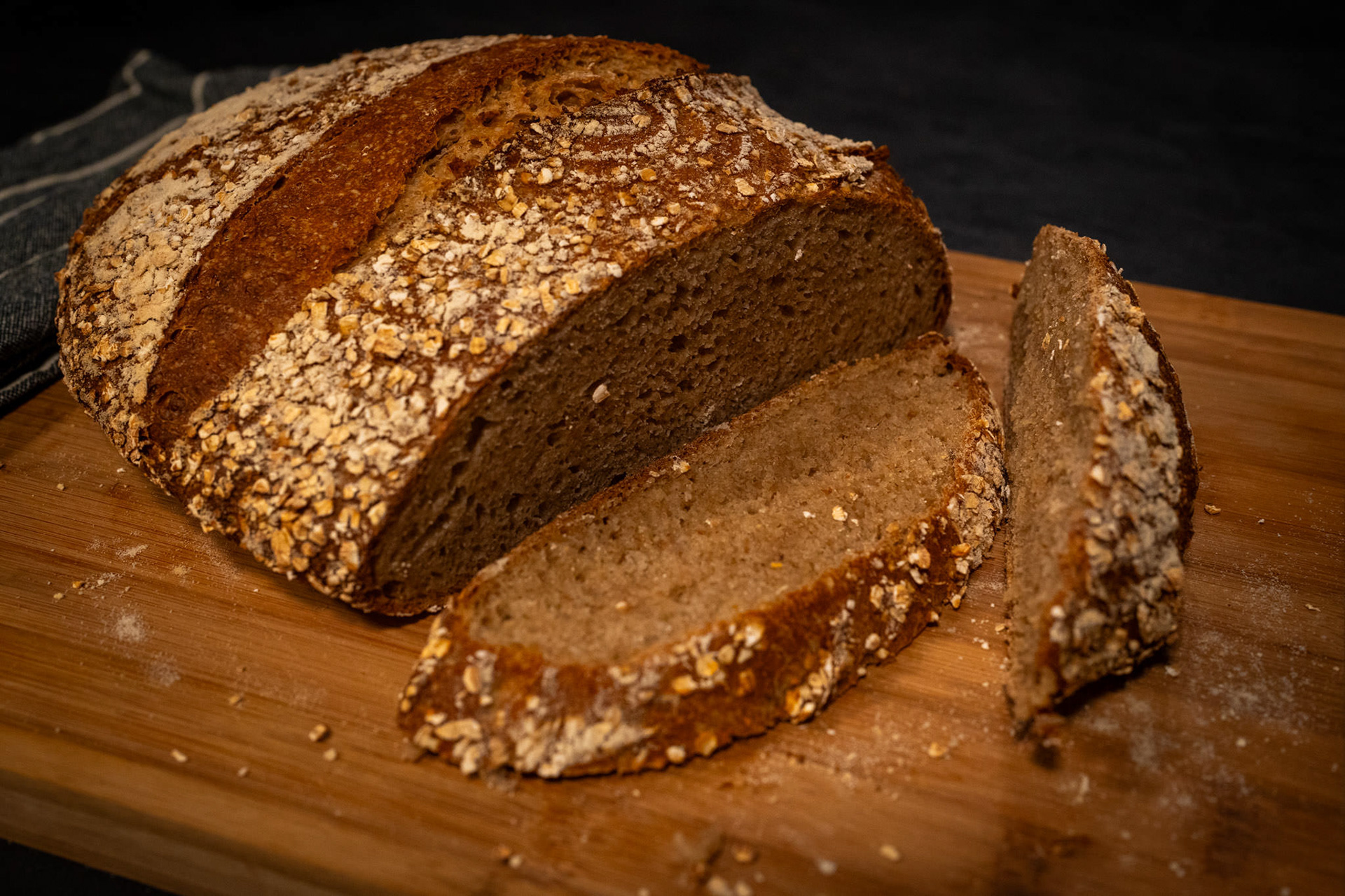 Freshly Baked Rye Bread – Rustic rye bread loaf sliced on a wooden cutting board.